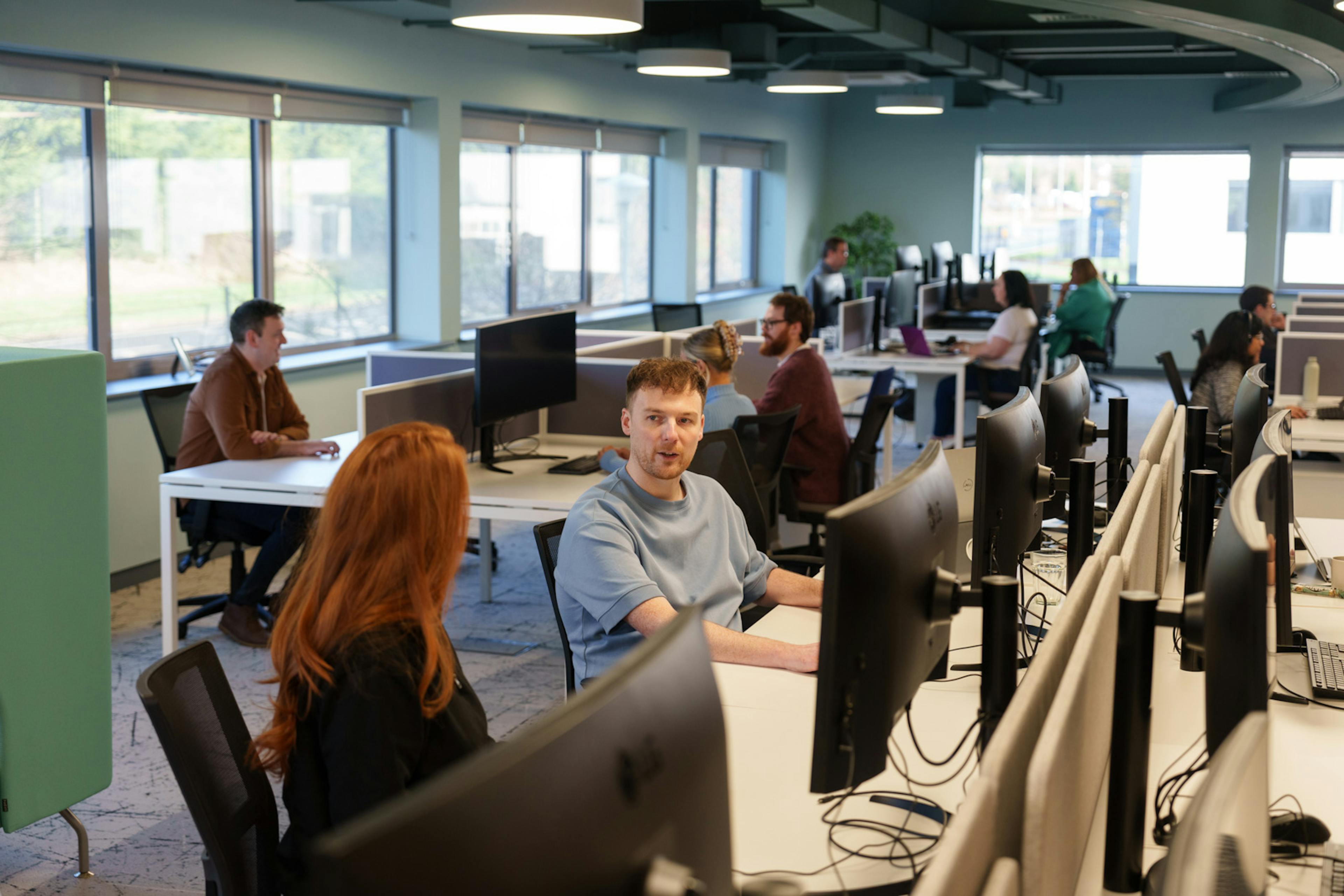 Two team members chatting in an open office space