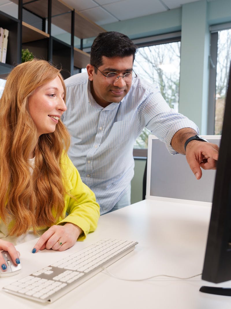 Two team members looking at a screen