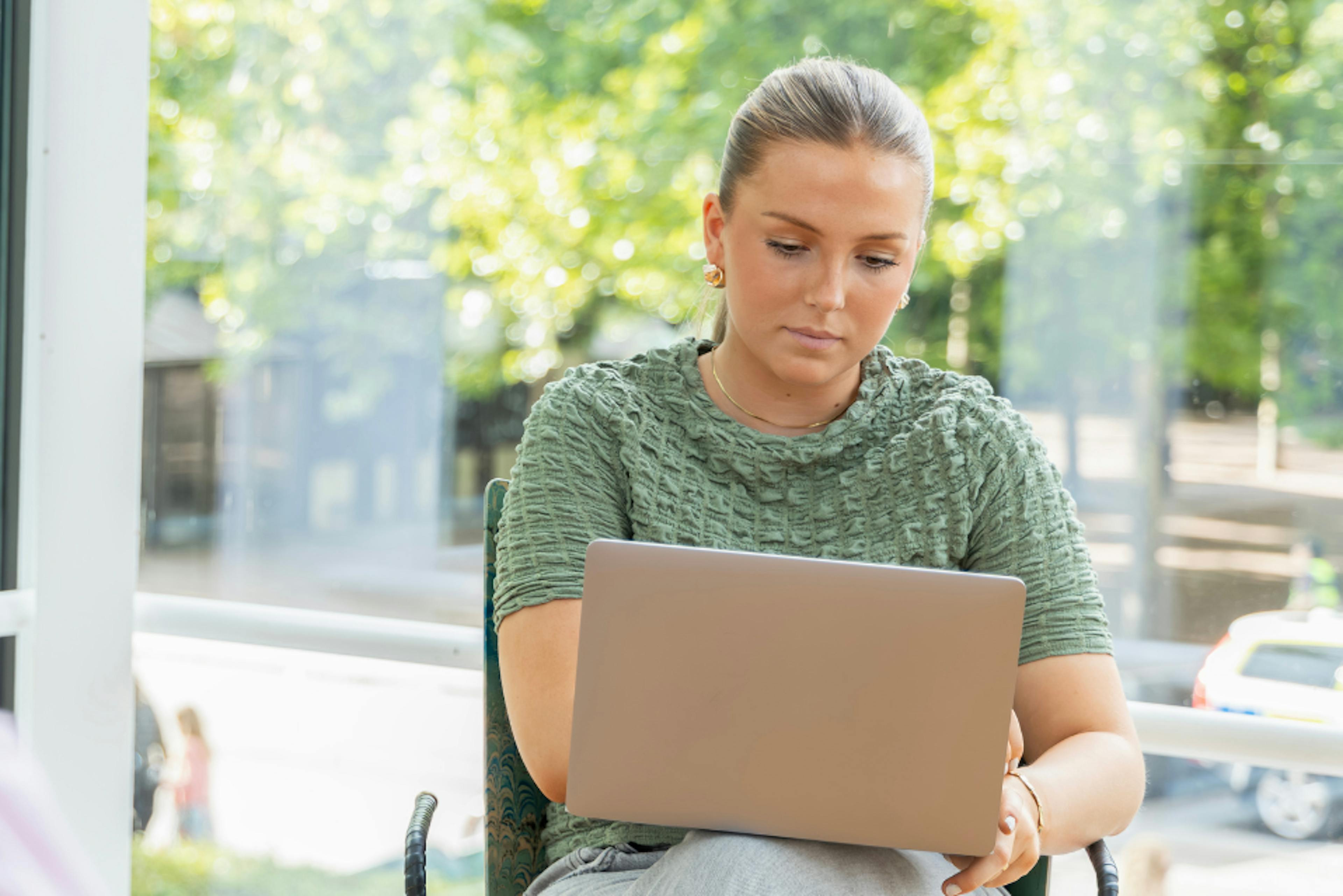 two girls one with a laptop on their knee