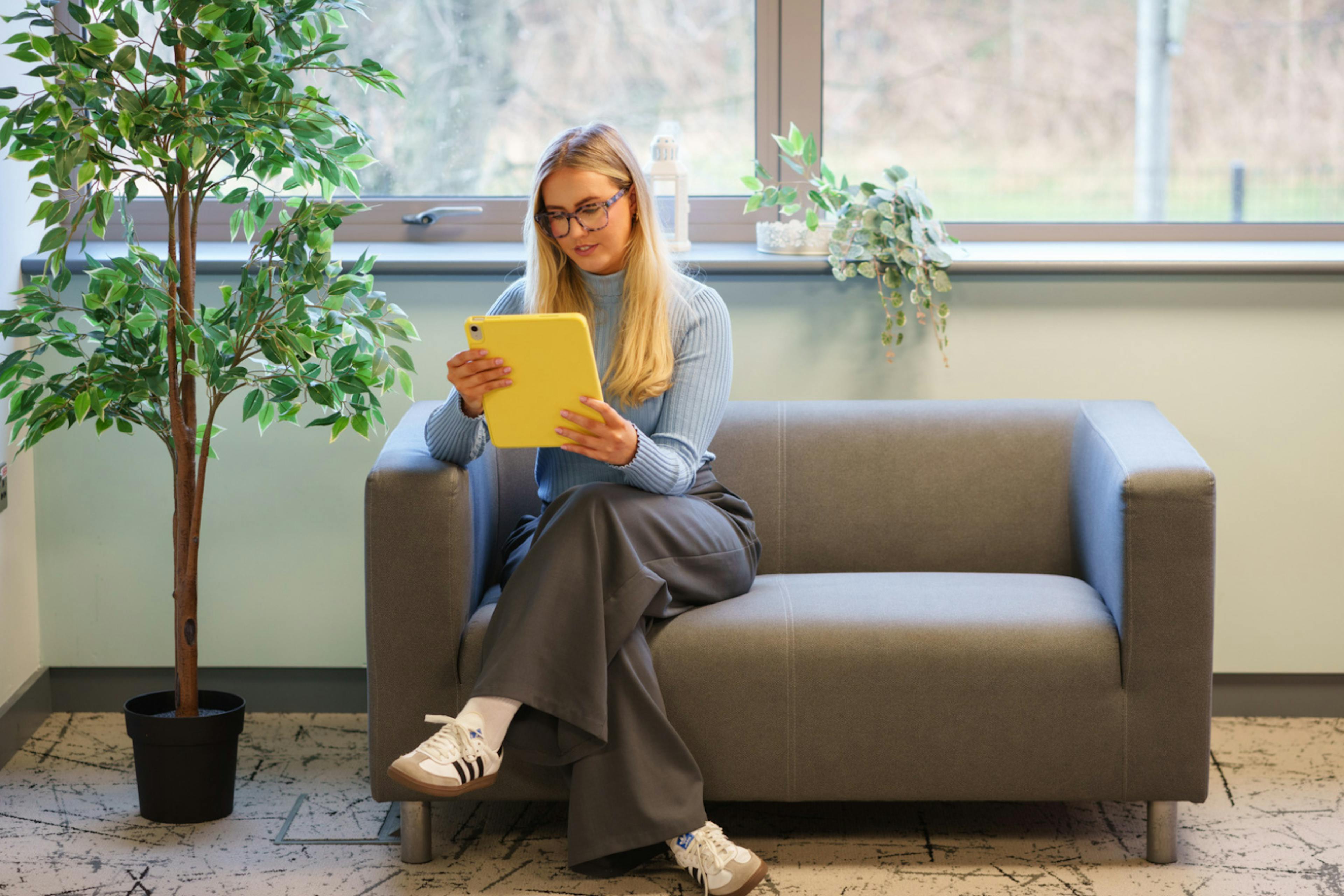 a girl on a sofa using an ipad