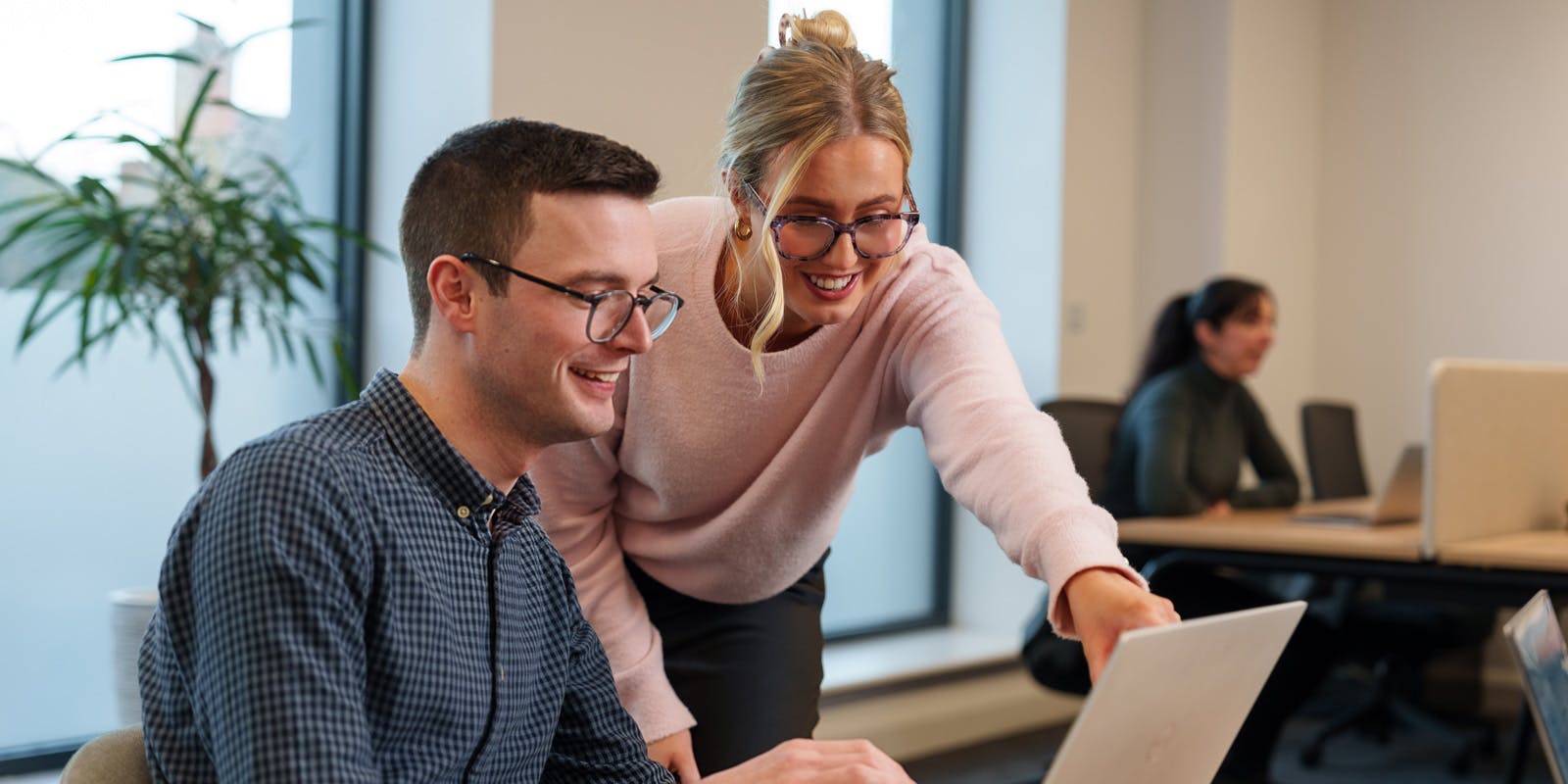 To profesjonelle som bruker en datamaskin sammen på et kontor