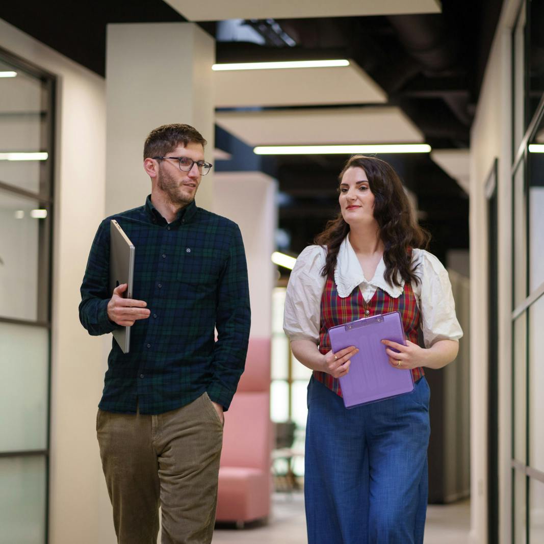 Two employees walking in an office