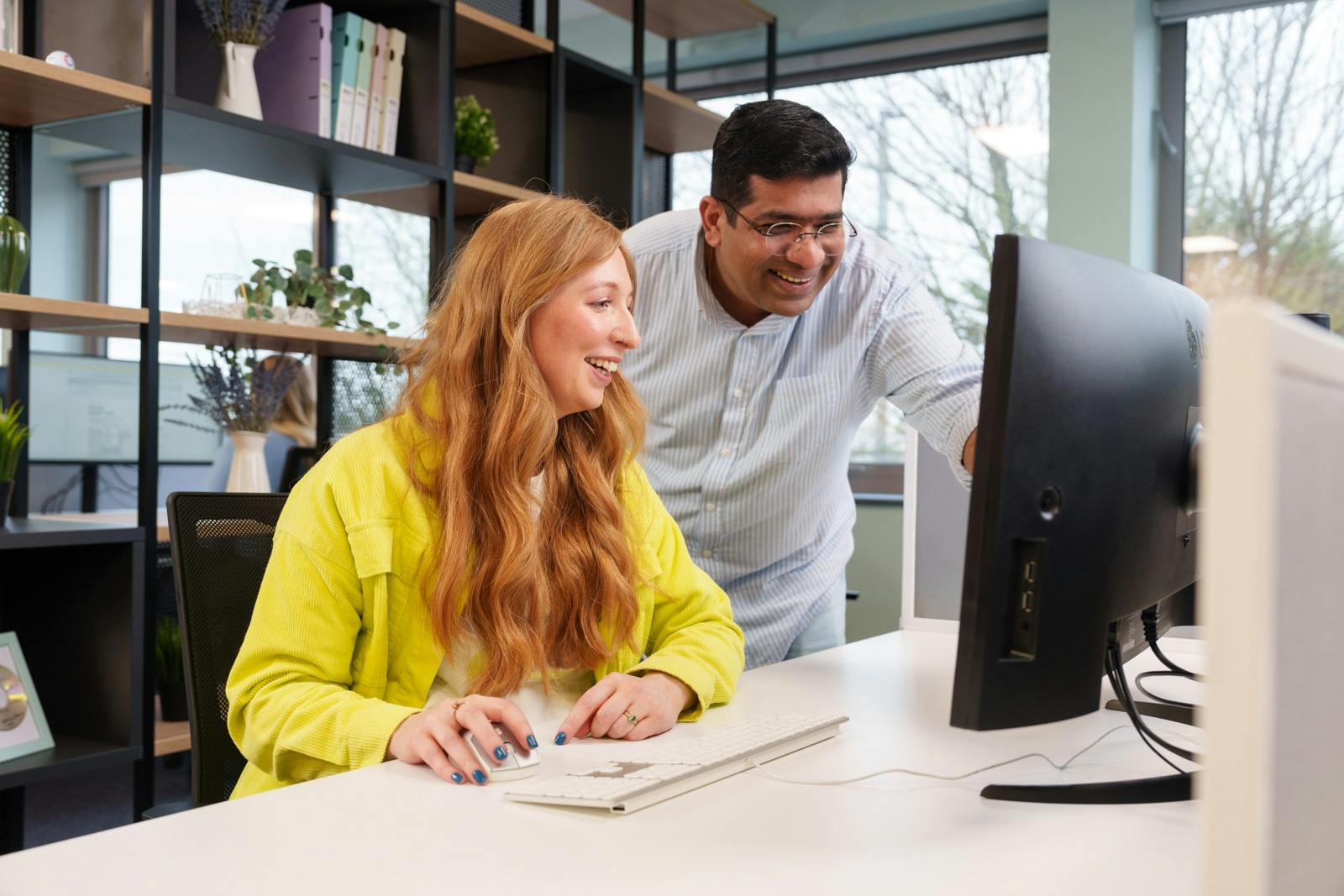 Two Everway team members discussing the contents of a computer screen