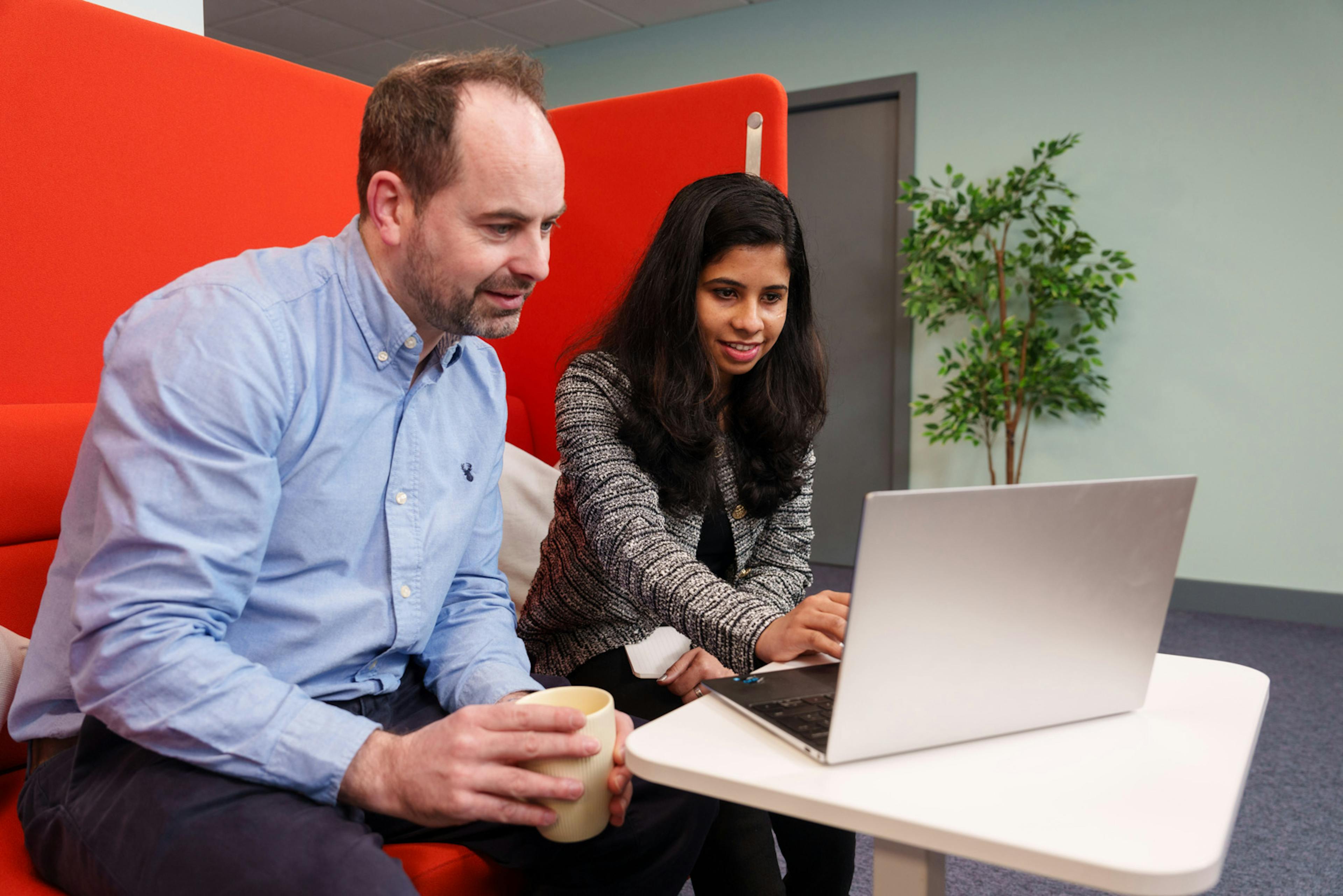 a man and woman looking at a laptop