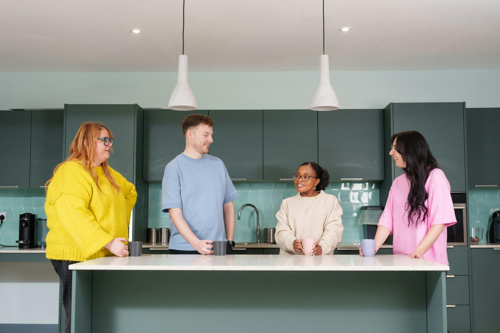 a group of people standing around a kitchen island