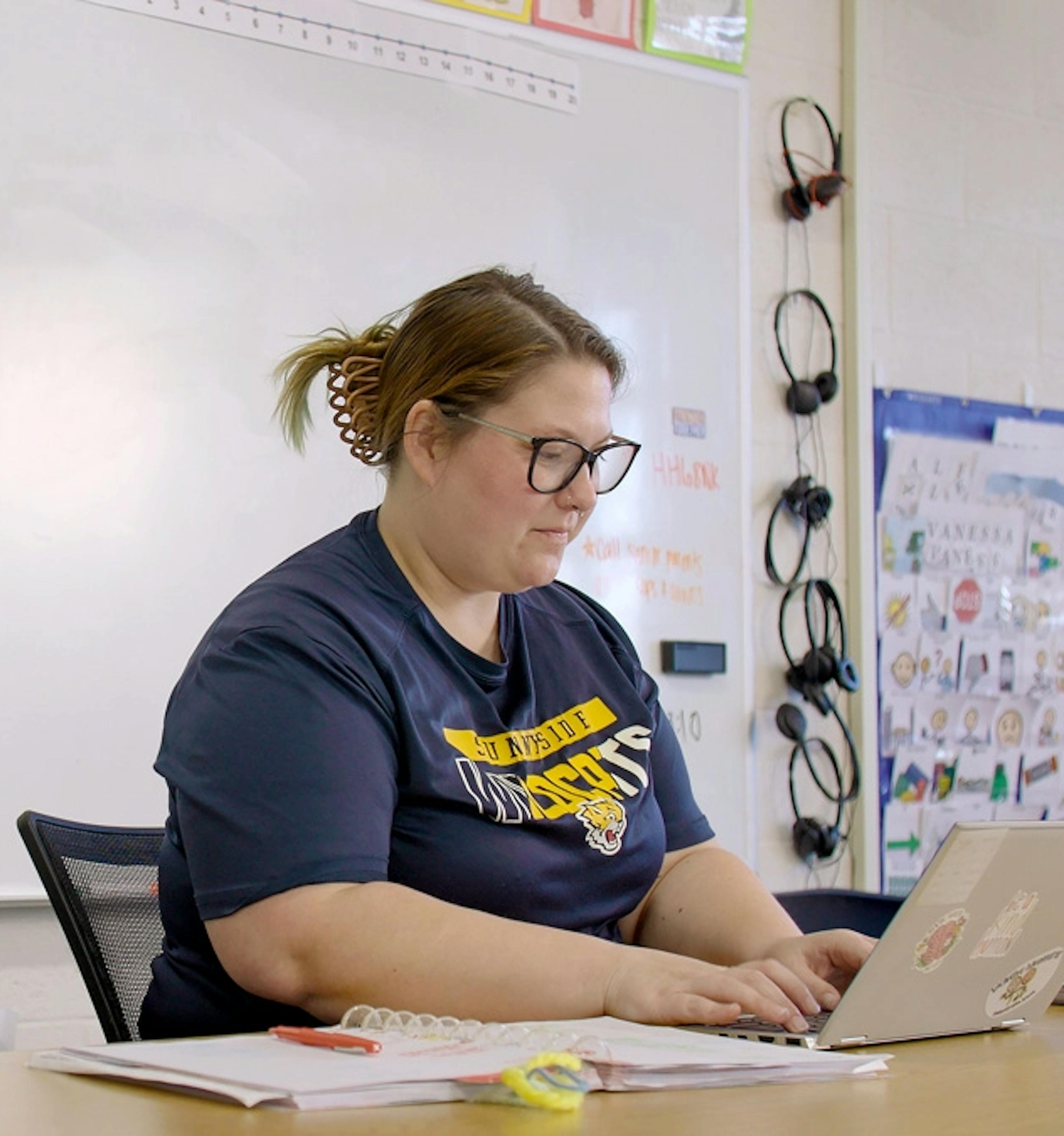 A teacher using a laptop in class