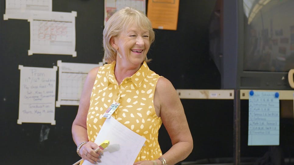 A teacher standing in front of a display board