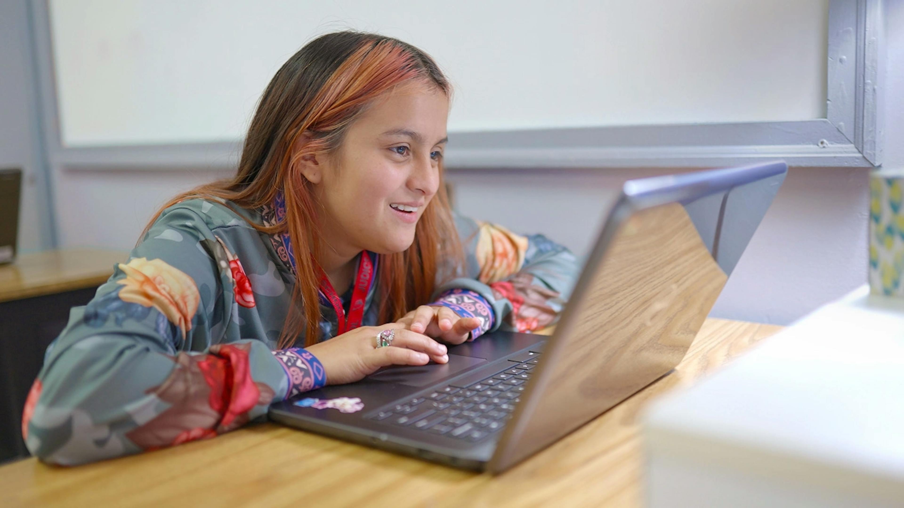 A student sitting a desk with a laptop