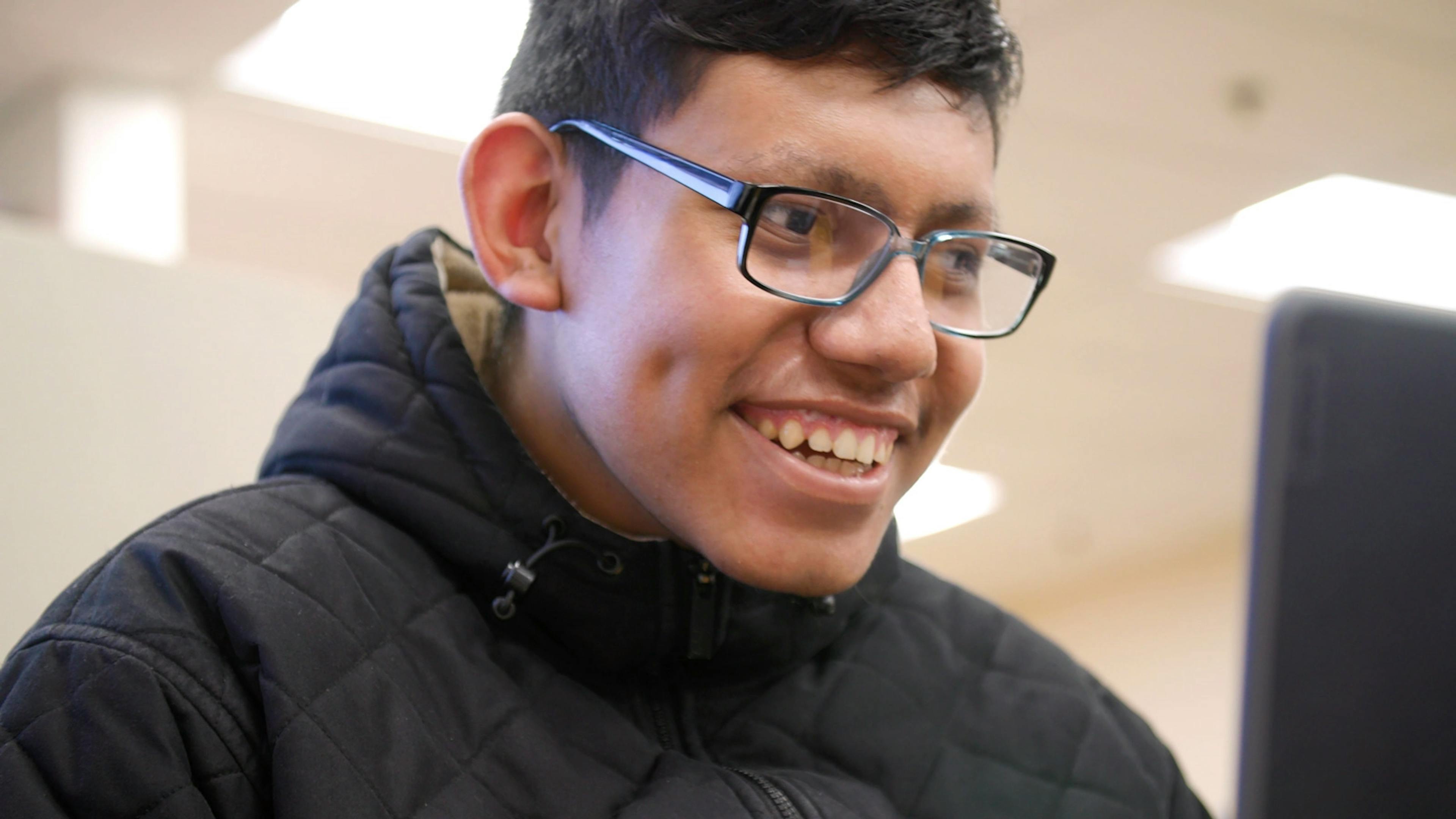 A student with glasses working