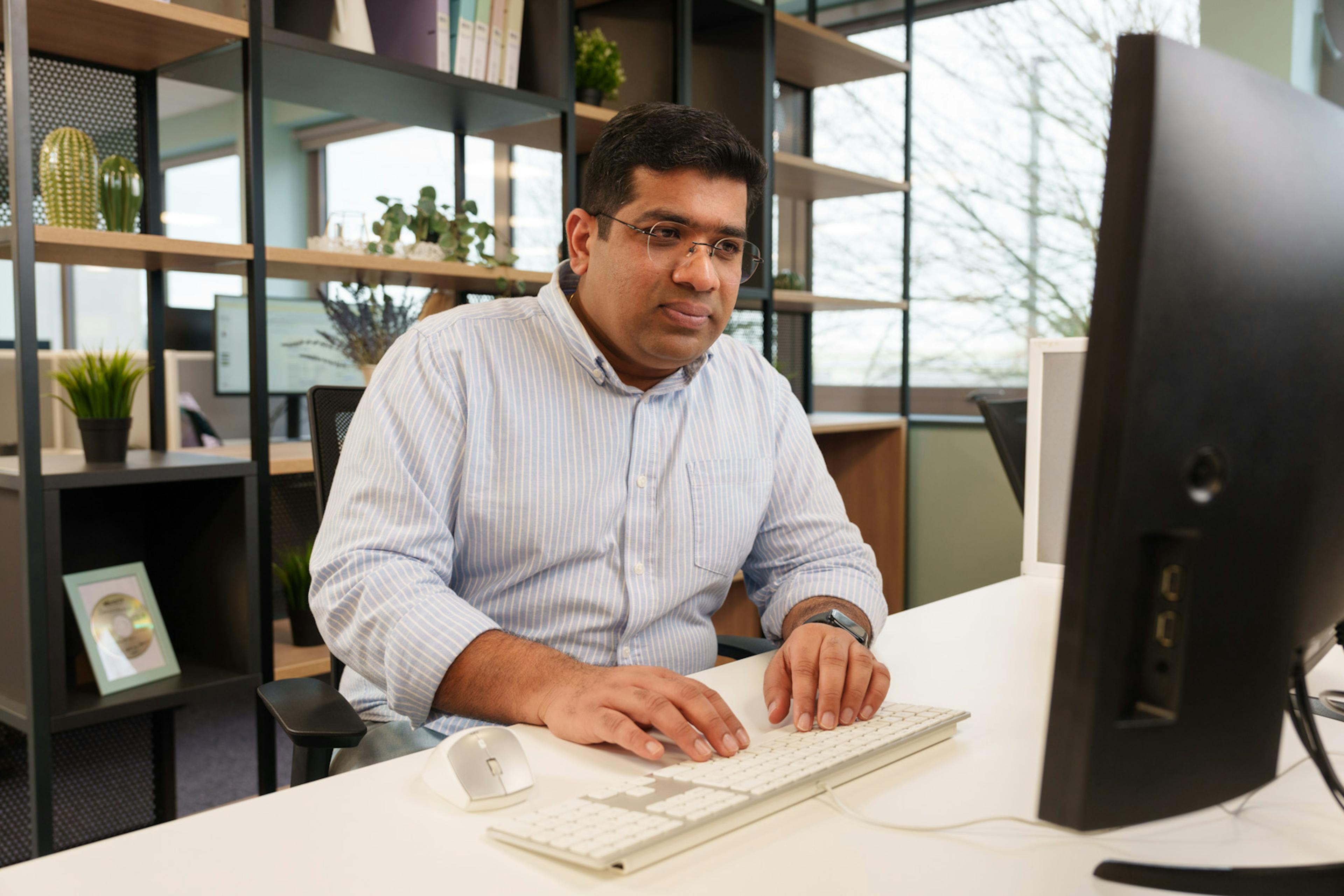 An individual sitting at a desk working on a computer