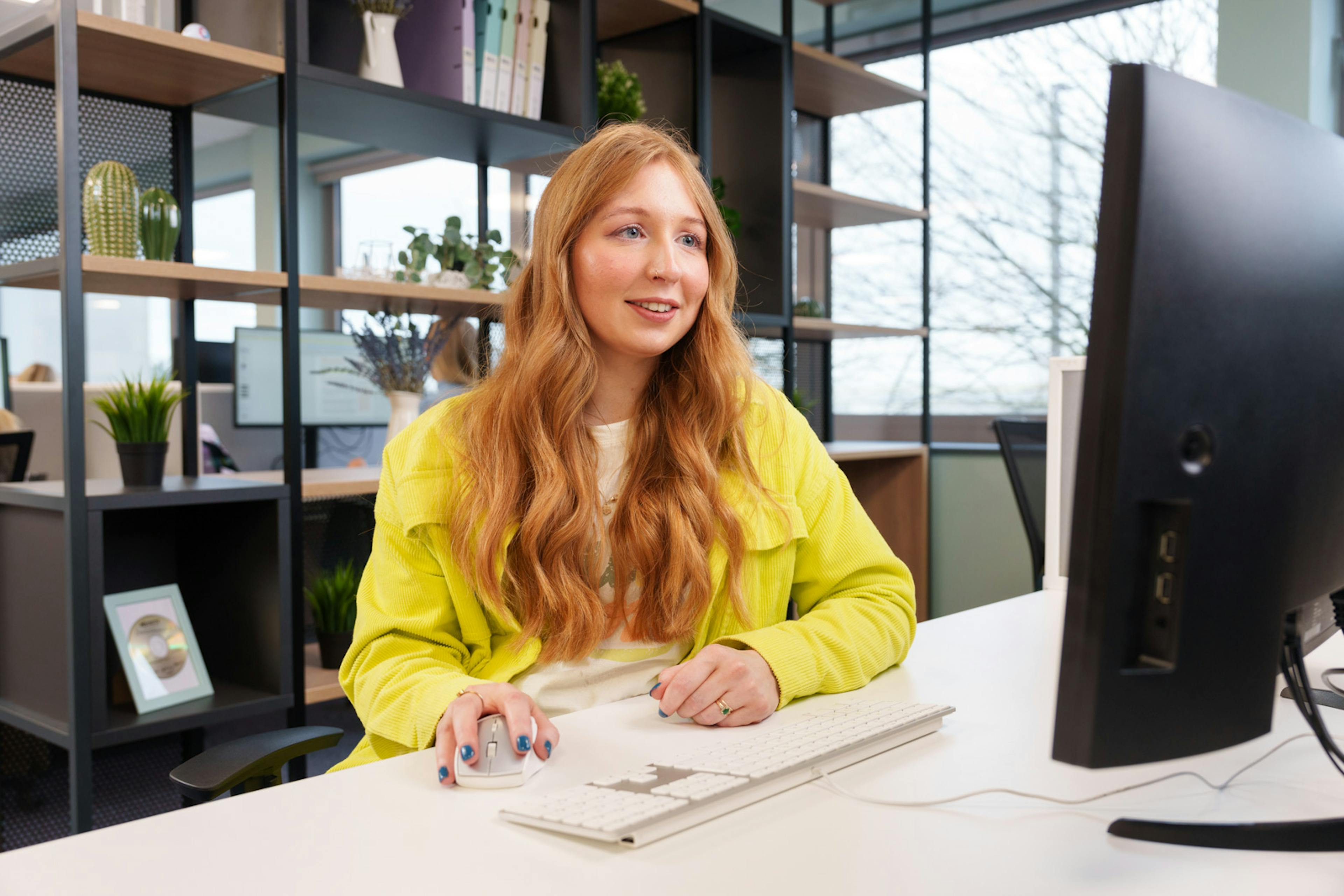 A person sitting at a desk looking at their computer screen