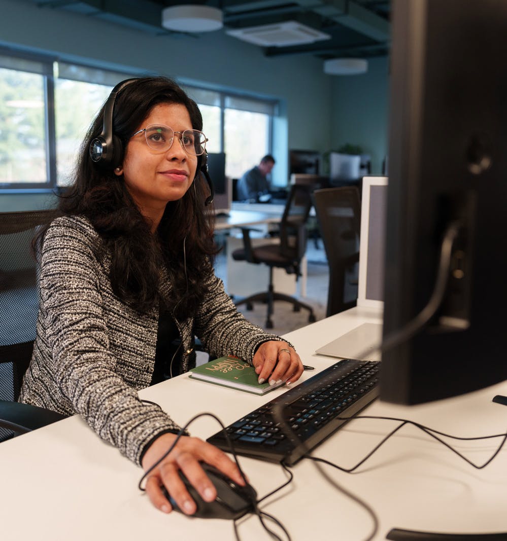 Employee in an office using a computer with a headset on