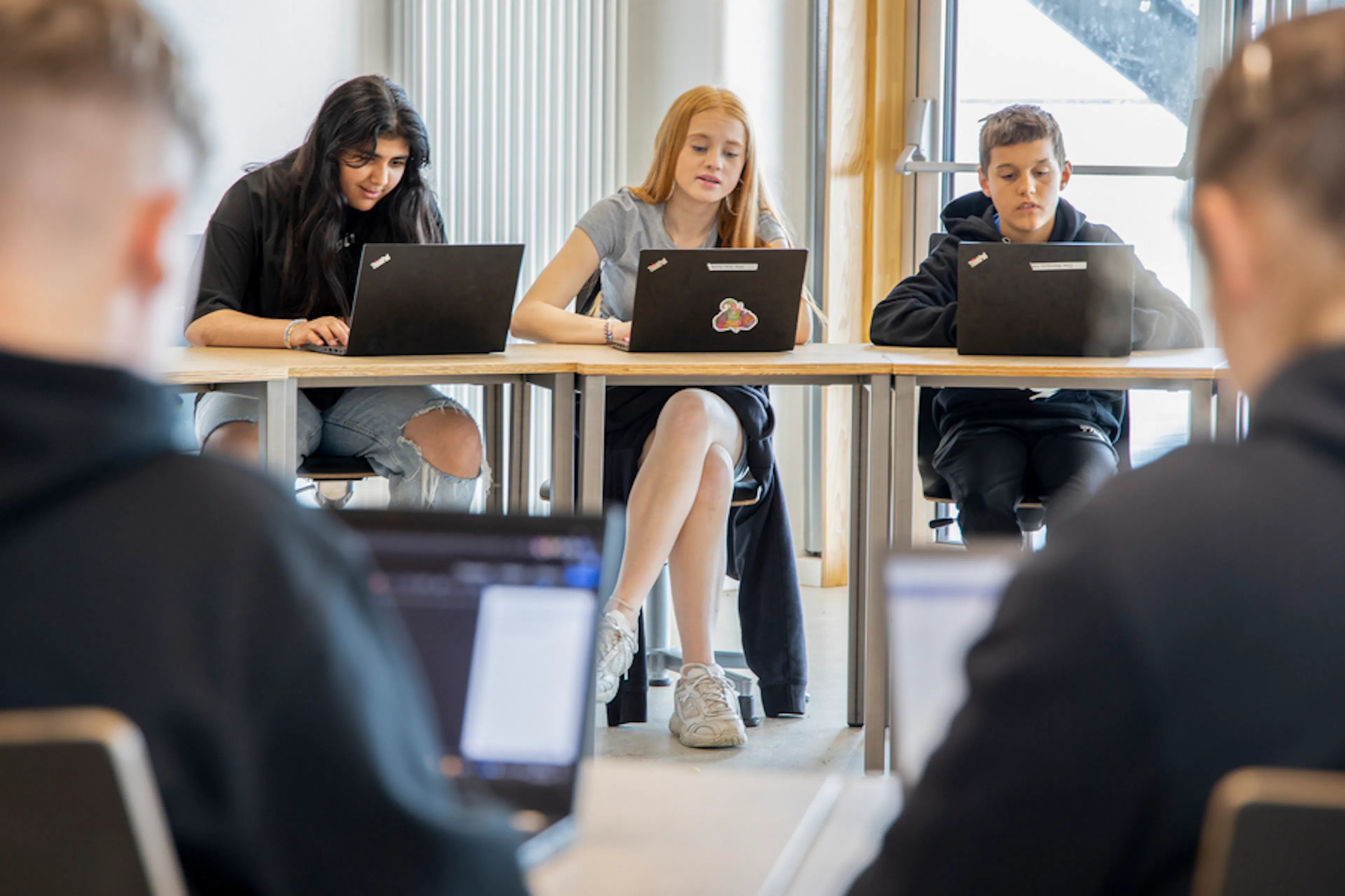 A classroom with six students sitting around desks
