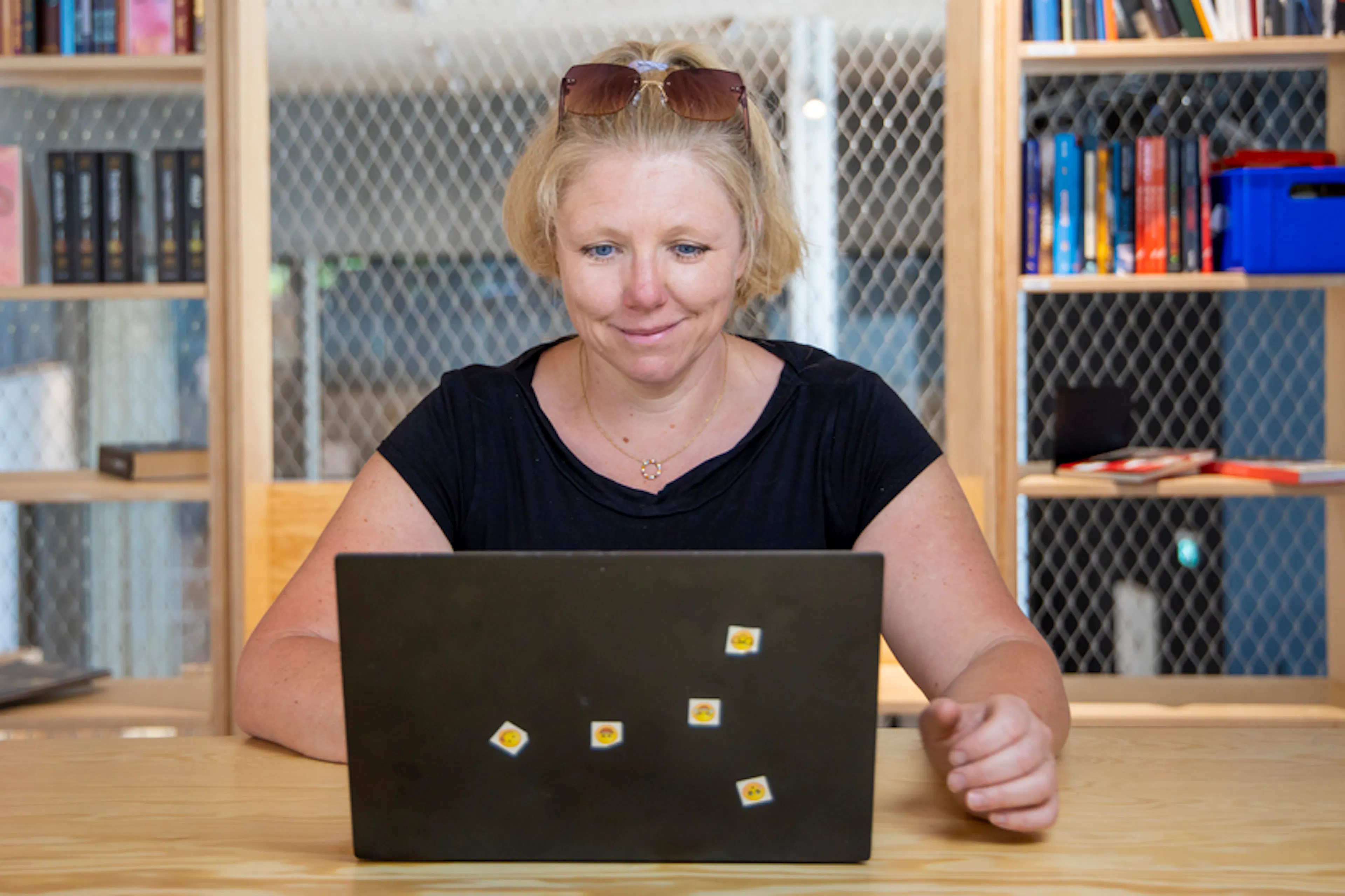 A teacher, sitting at a desk with a laptop