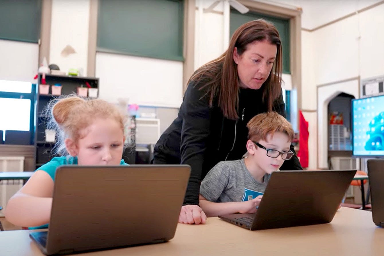 Two students being supervised by a teacher
