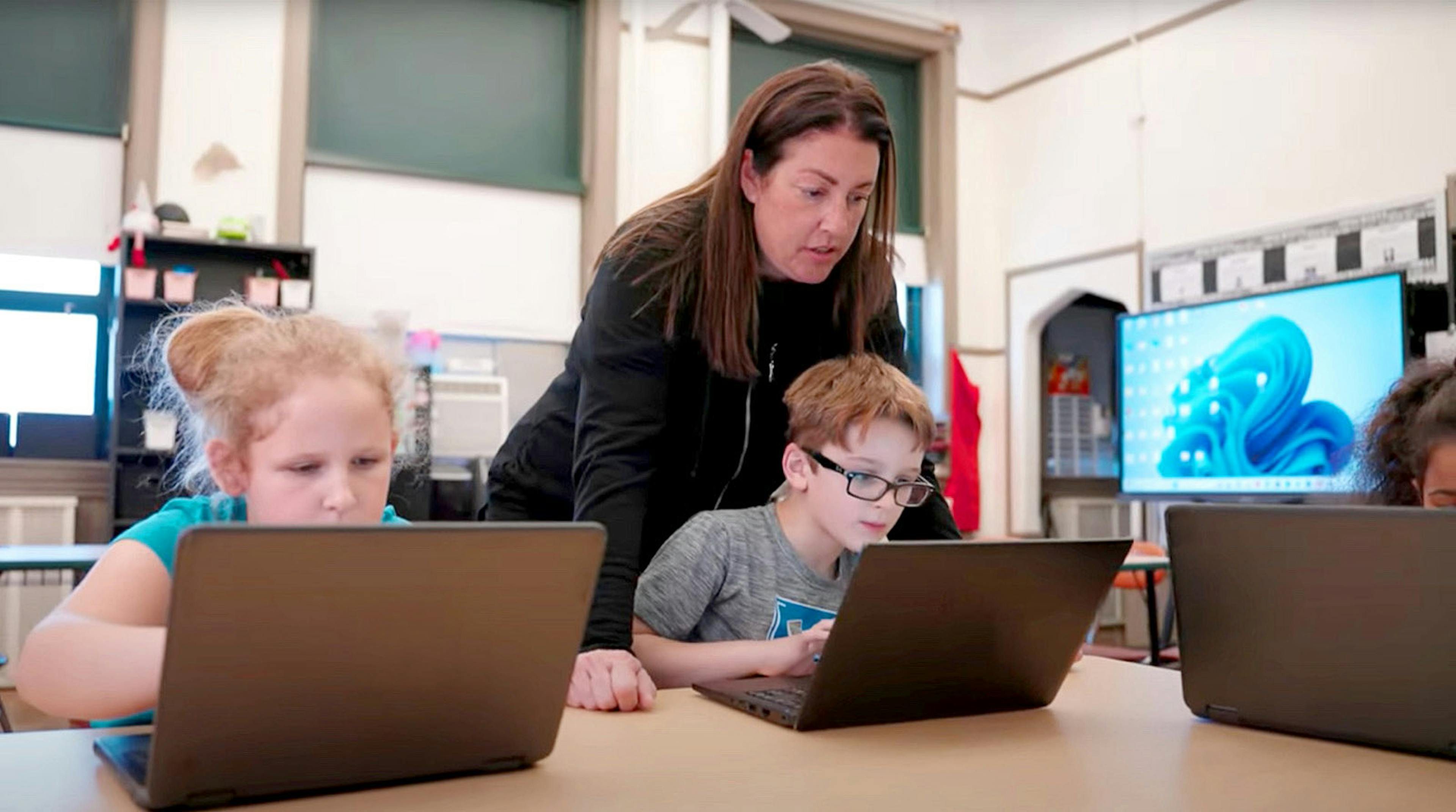 Two students being supervised by a teacher
