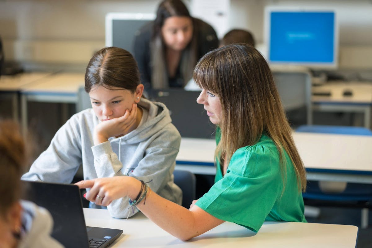 A teacher and a student using a laptop