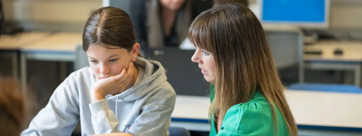 A teacher and a student using a laptop