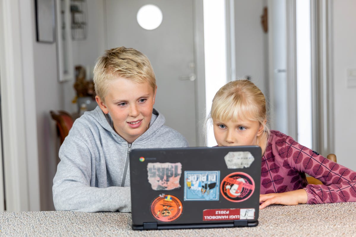 Two students working on a laptop