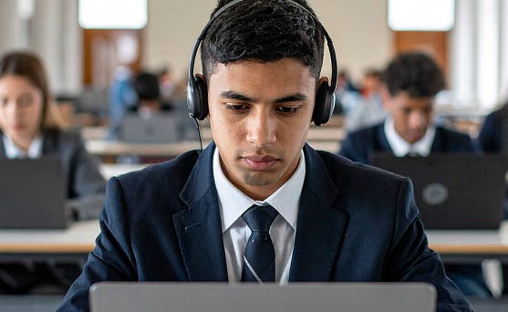 Student working on laptop wearing headphones