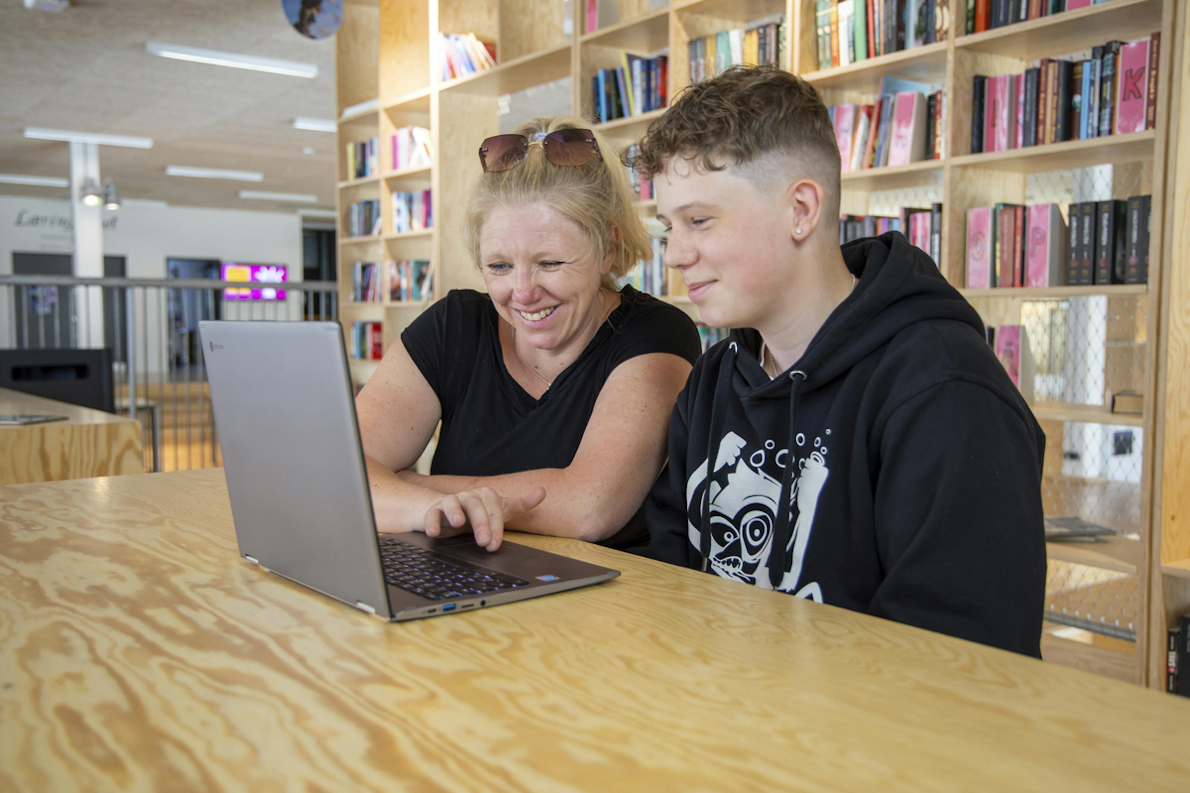 En lærer og en elev bruger en bærbar computer sammen