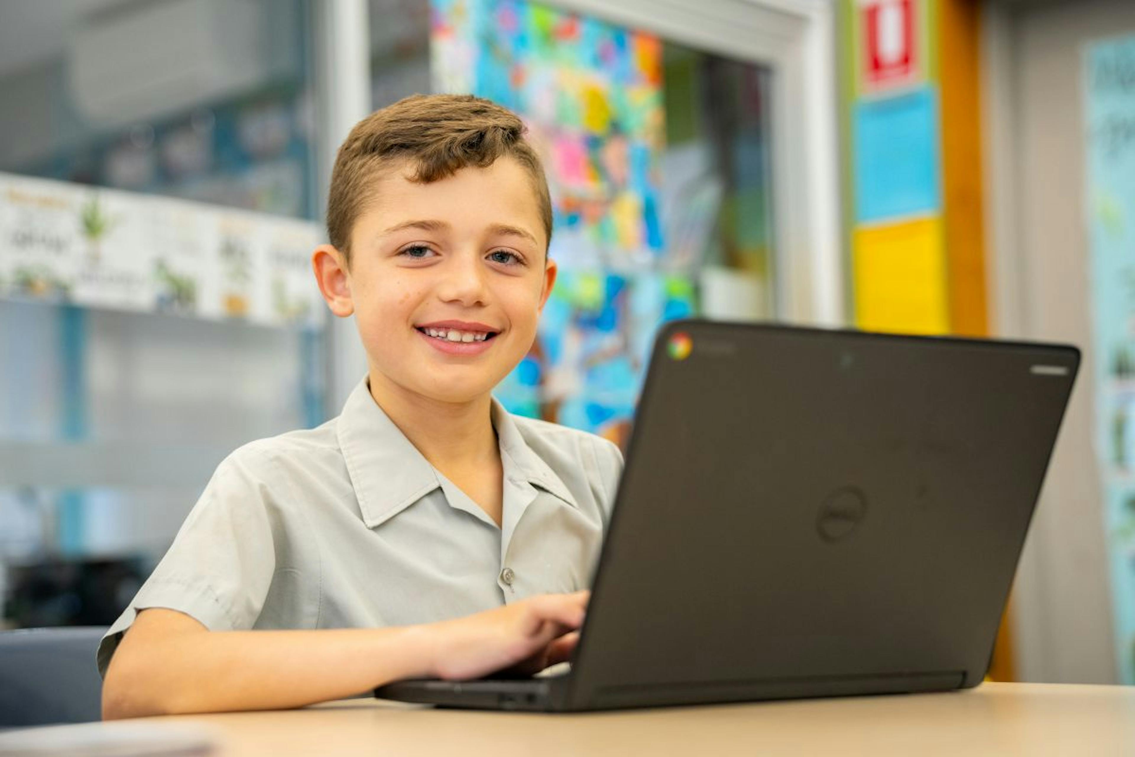 Student smiling with a laptop