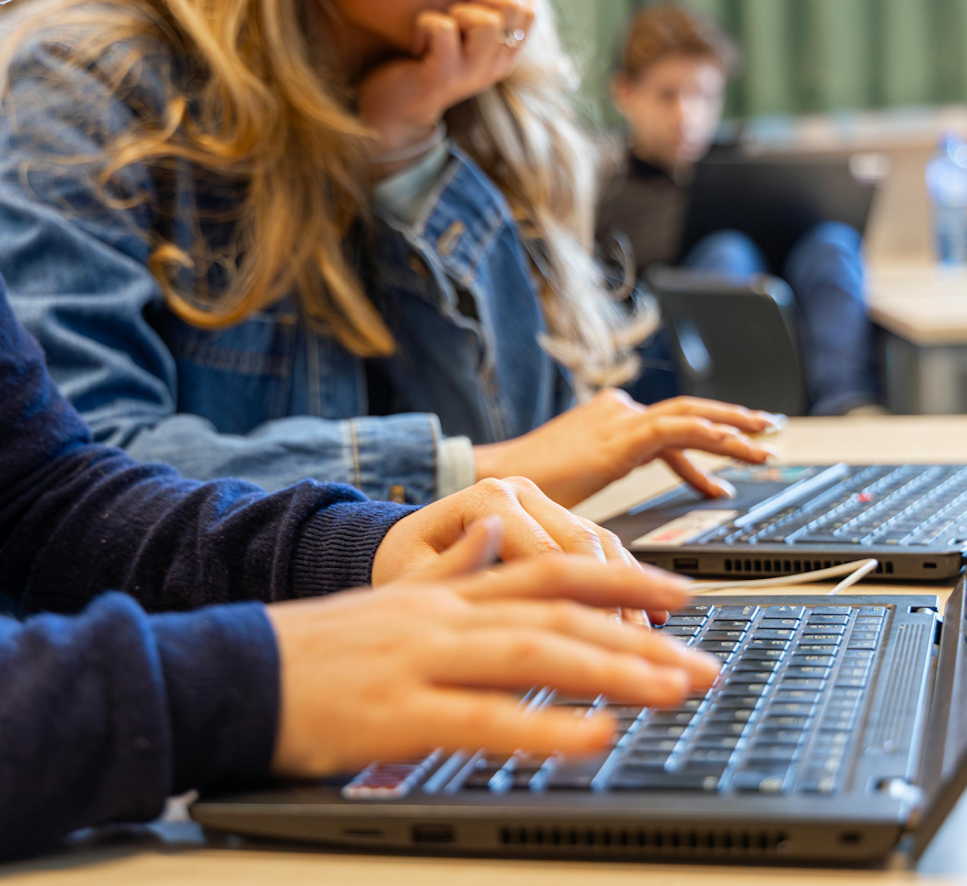 Hender som skriver på et bærbart tastatur