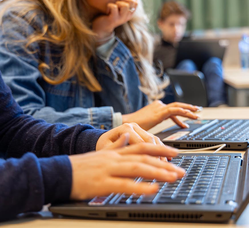 Hender som skriver på et bærbart tastatur