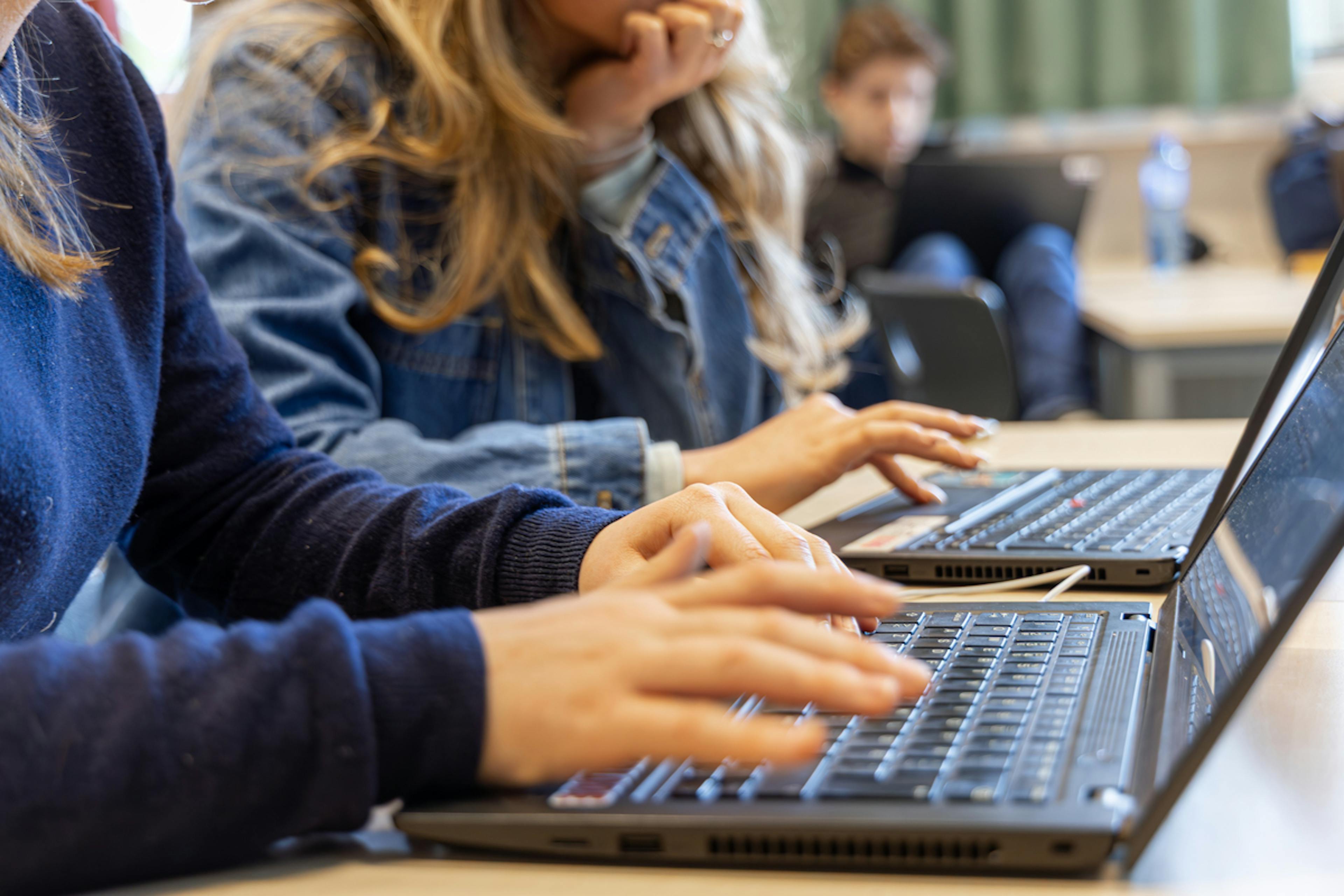 Hender som skriver på et bærbart tastatur