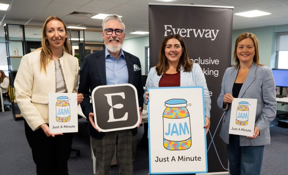 Claire McCleery Director of Business Development at NOW Group, Martin McKay Founder and Executive Chair of Everway, Maeve Monaghan CEO of NOW Group, and Cathy Donnelly Chief People Officer at Everway, standing in an office holding signs with JAM cards and the Everway logo.
