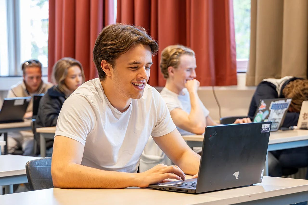 En student som bruker en bærbar PC i et klasserom