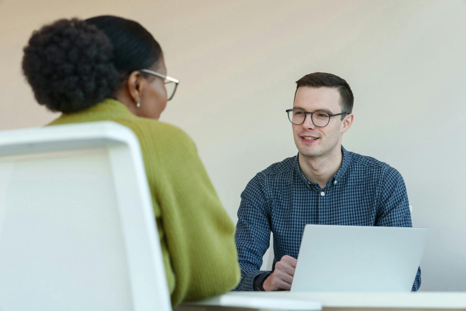 Two employees sitting at a table with a laptop