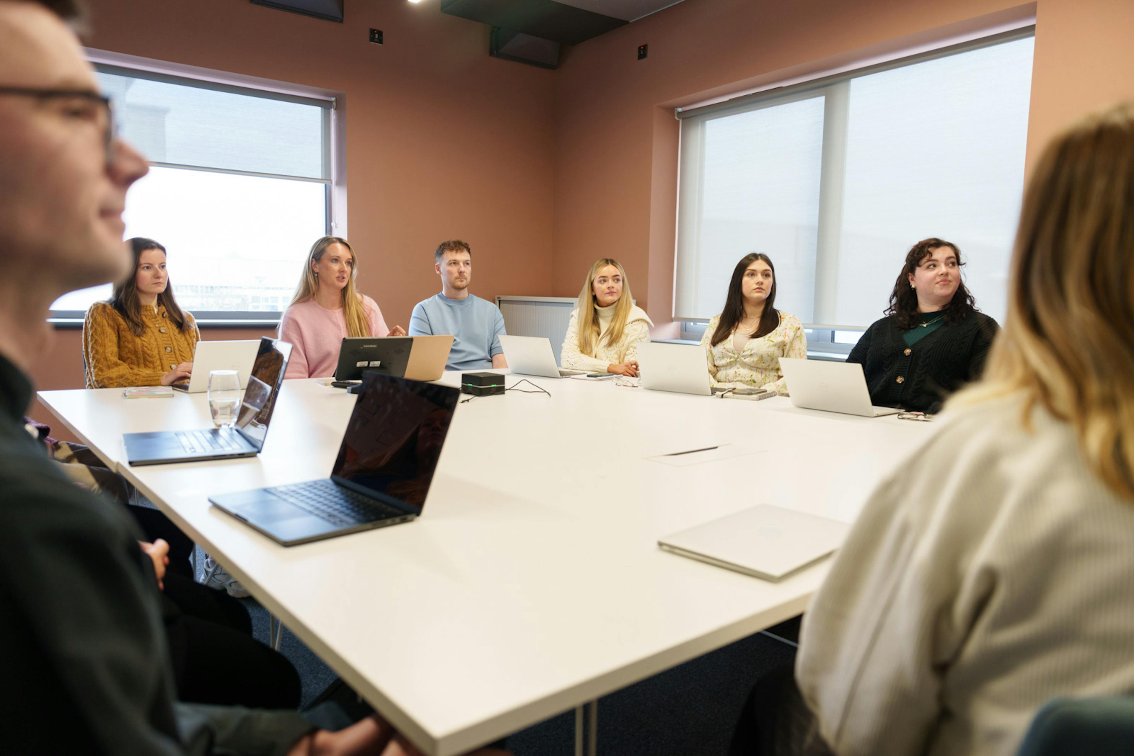 A diverse group of employees gathered around a table in an office 
