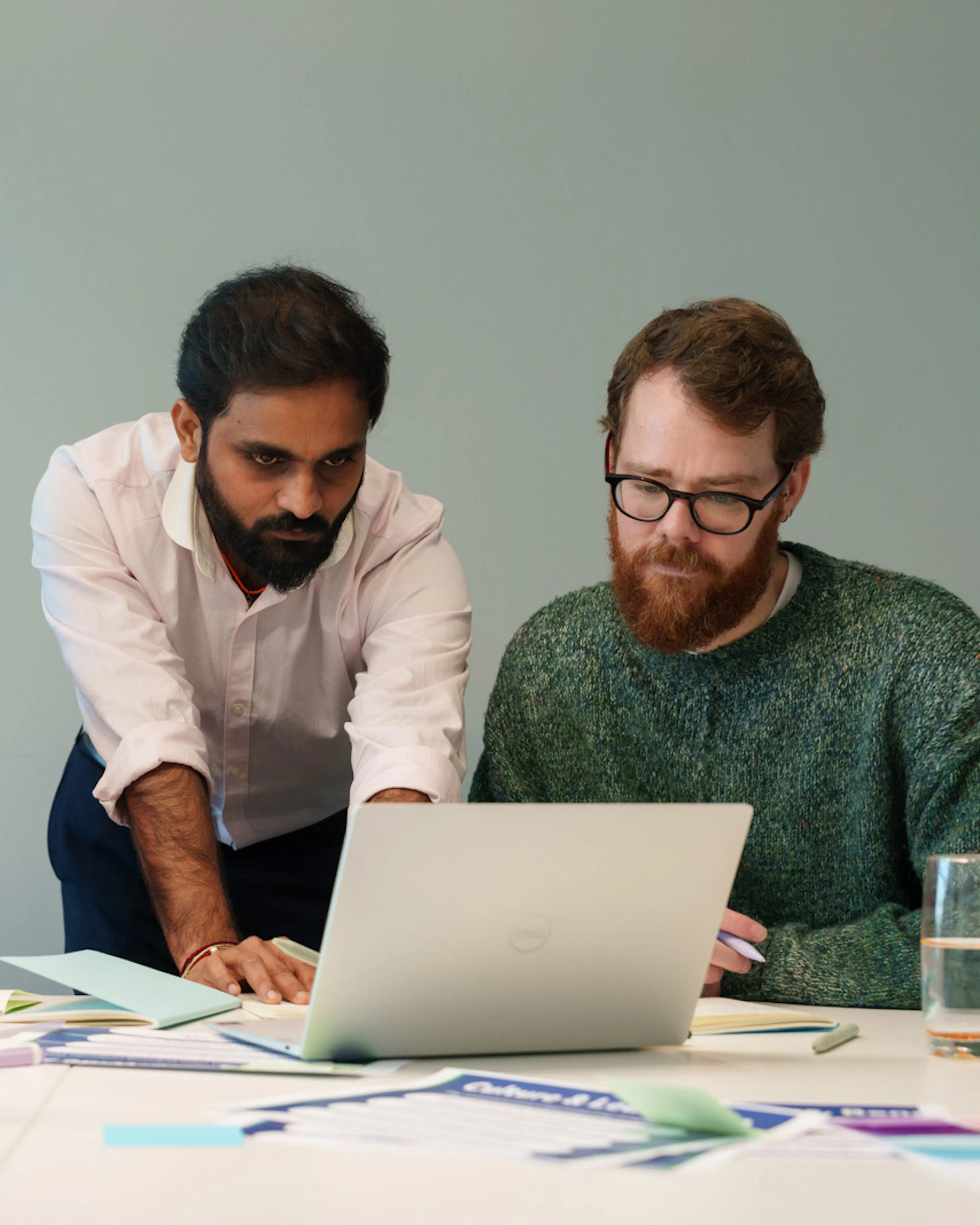 3 employees gathered around a laptop