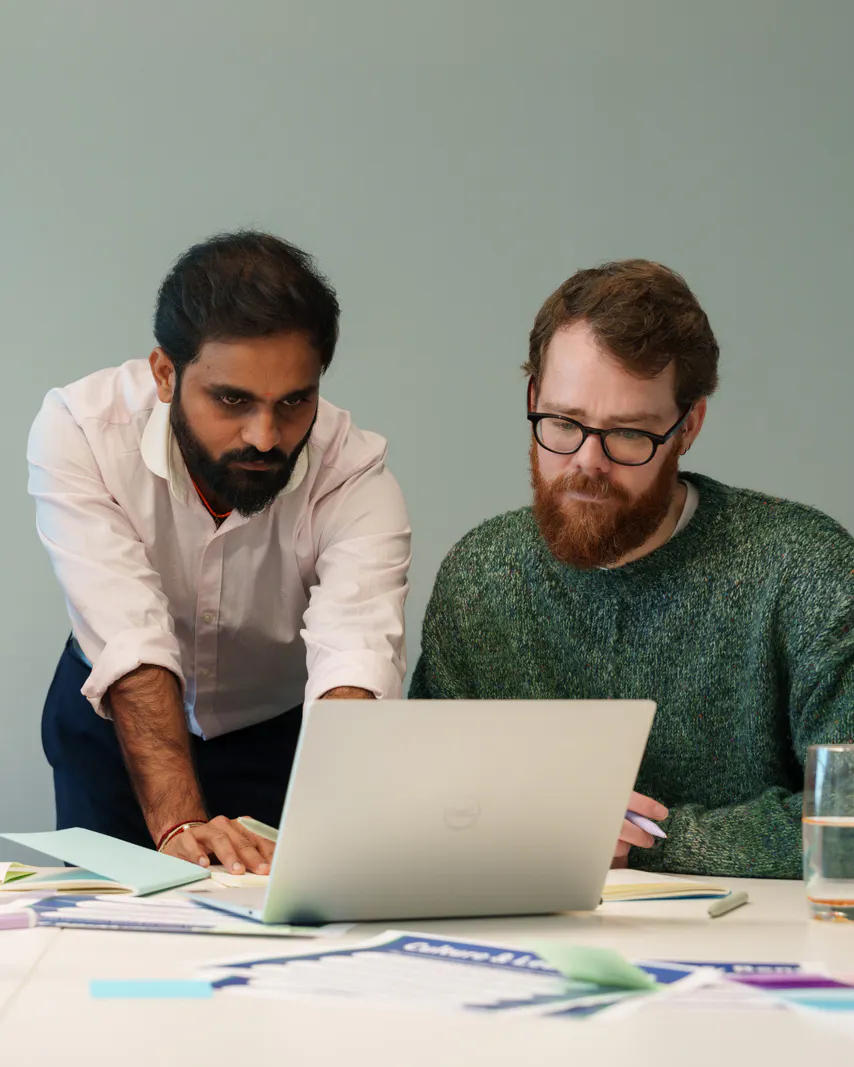 3 employees gathered around a laptop
