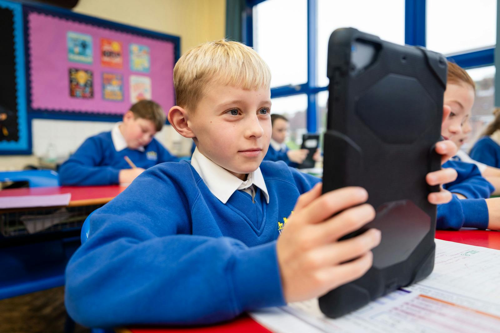 A student in a classroom using a tablet