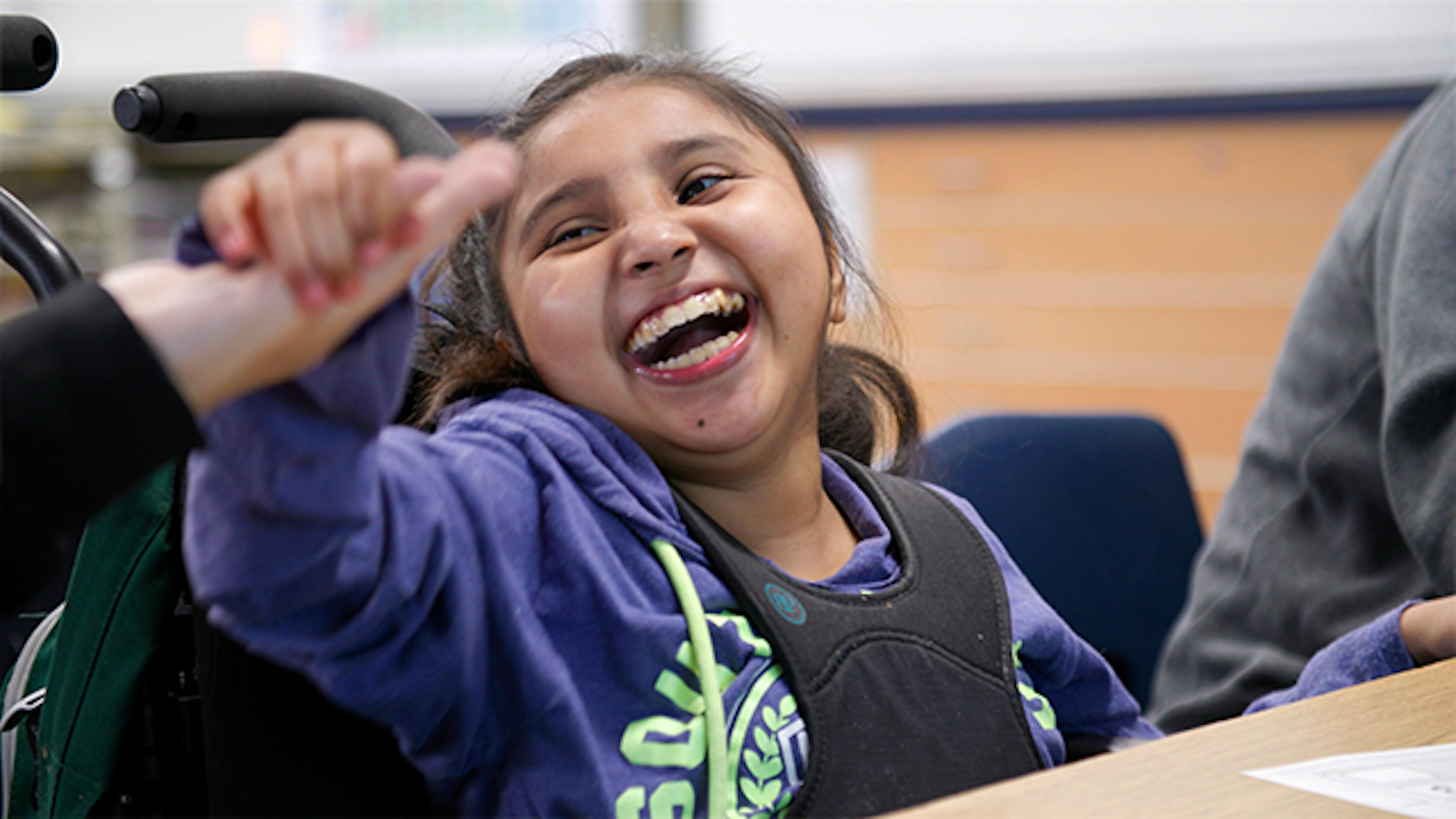 Student smiling holding hands