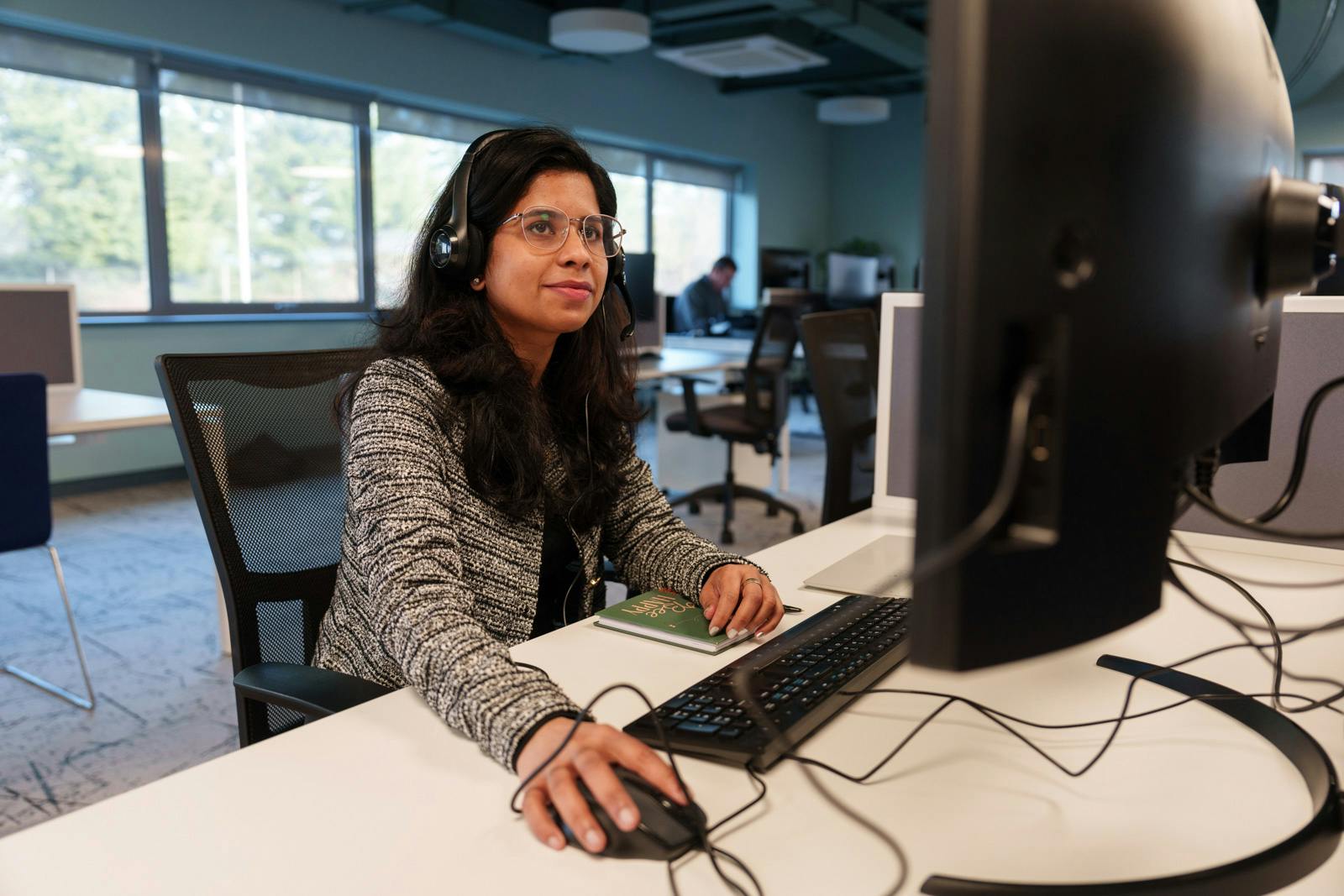 Employee wearing a headset working at a computer in an office.