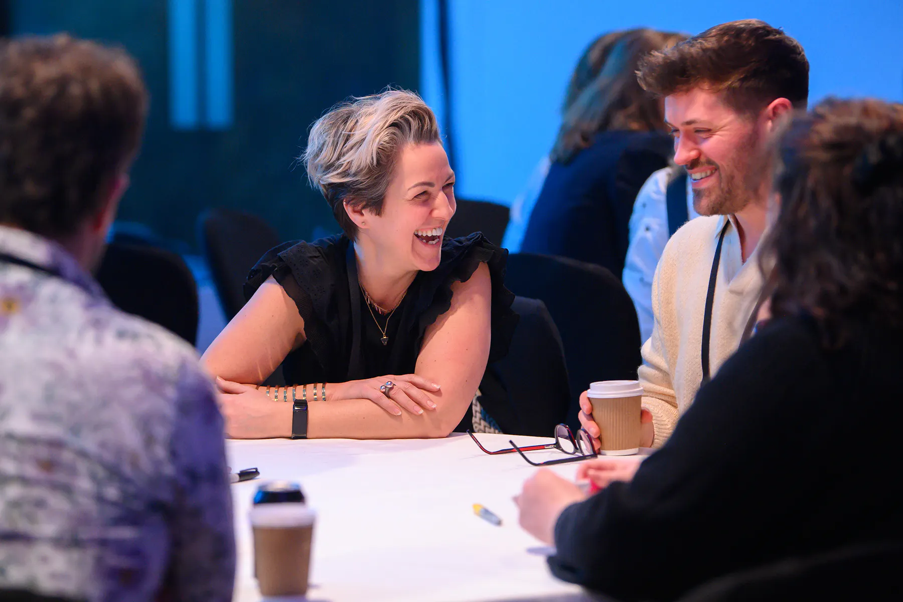 Employees smiling and working together at a company event workshop