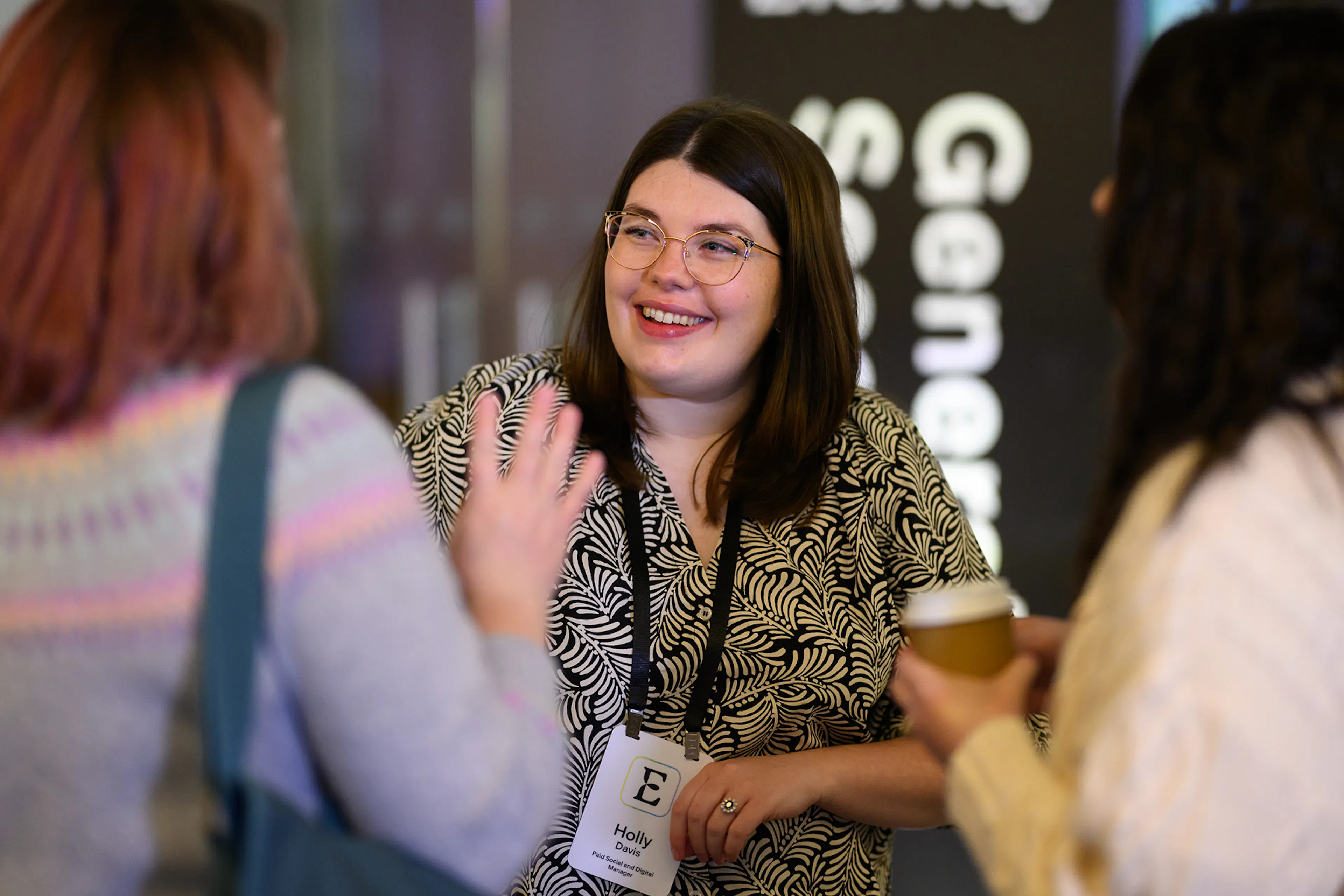 An employee in conversation with others at an event. 