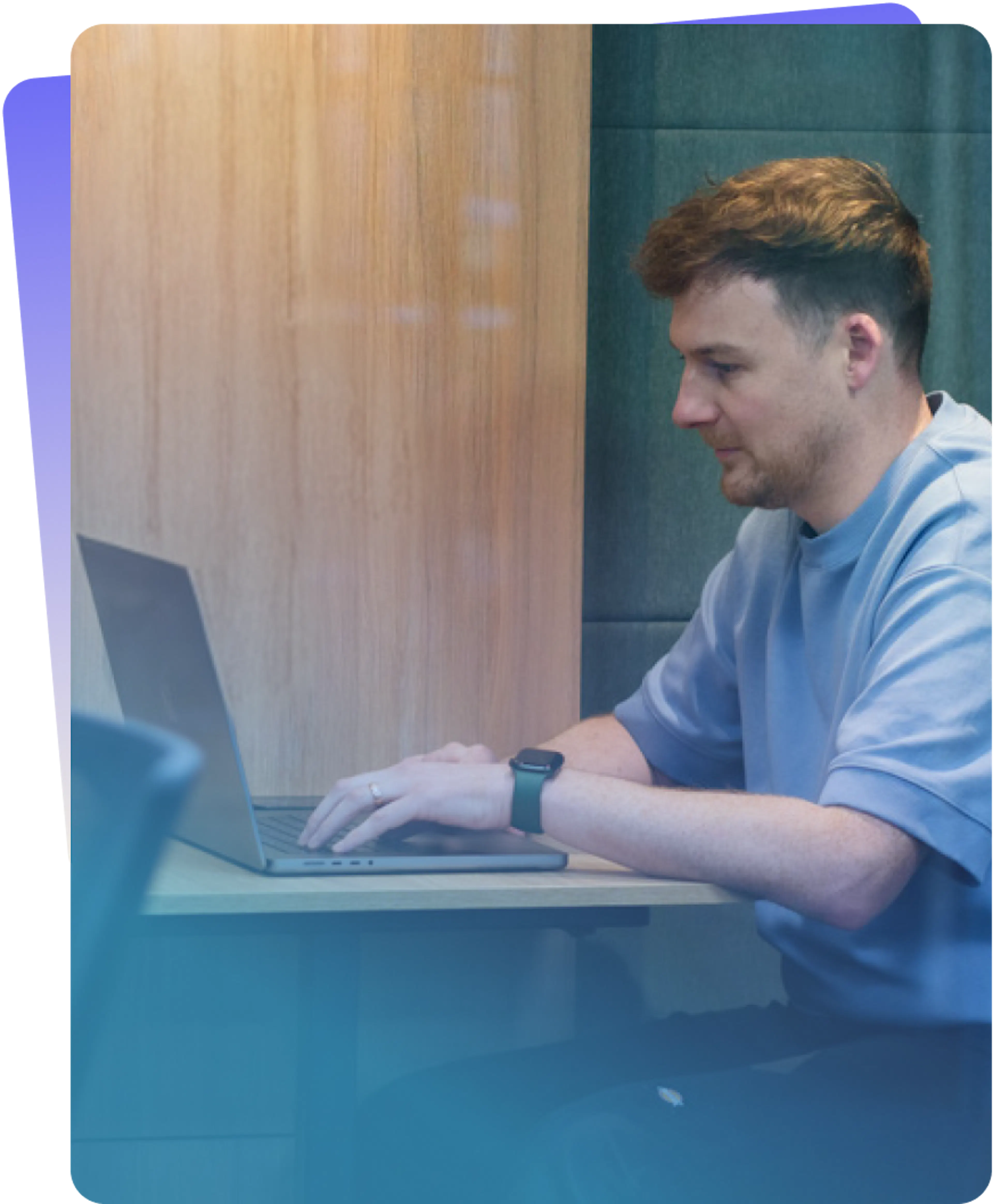 An Employee working on a laptop in a meeting booth