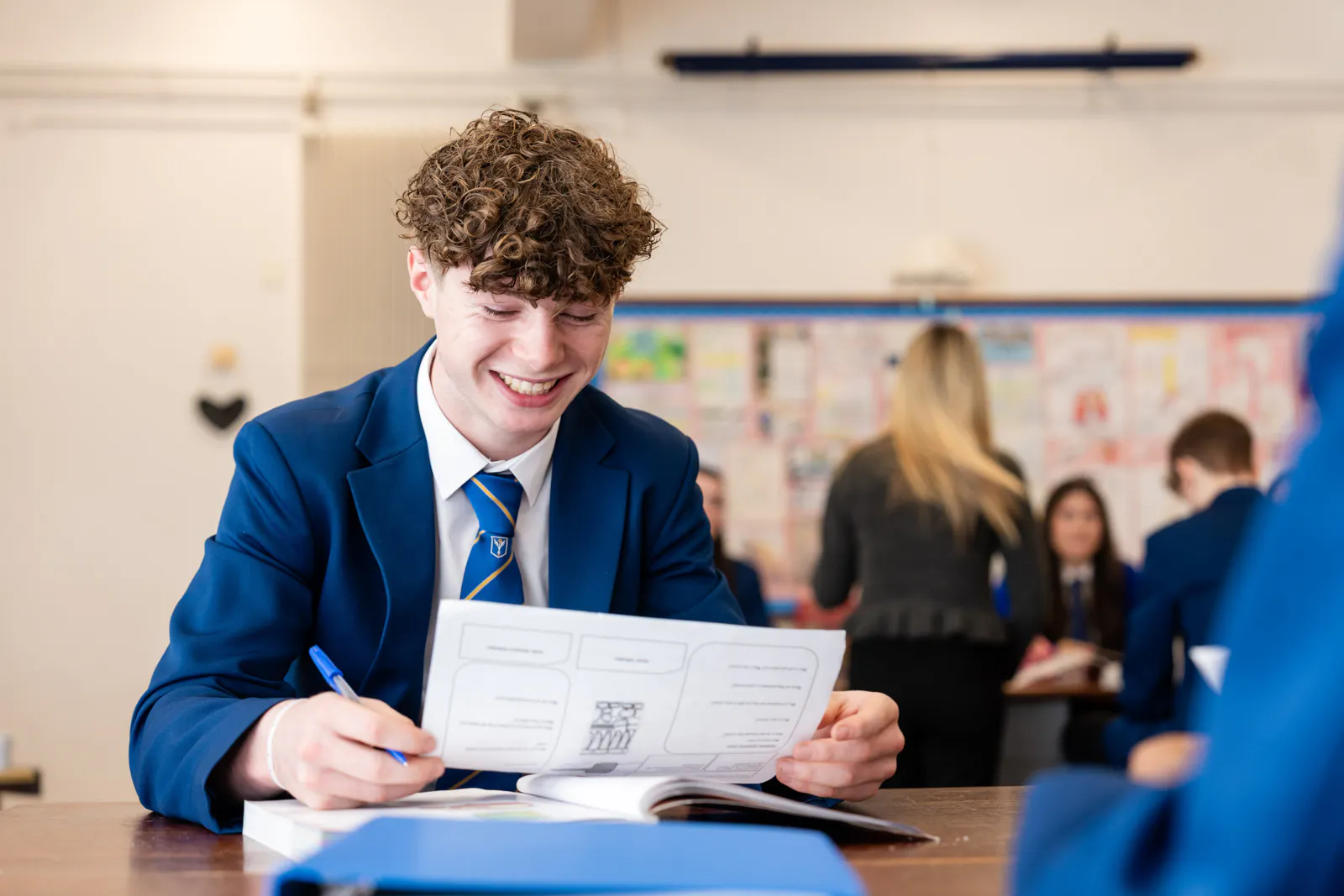 A student sitting at a desk reading a worksheet