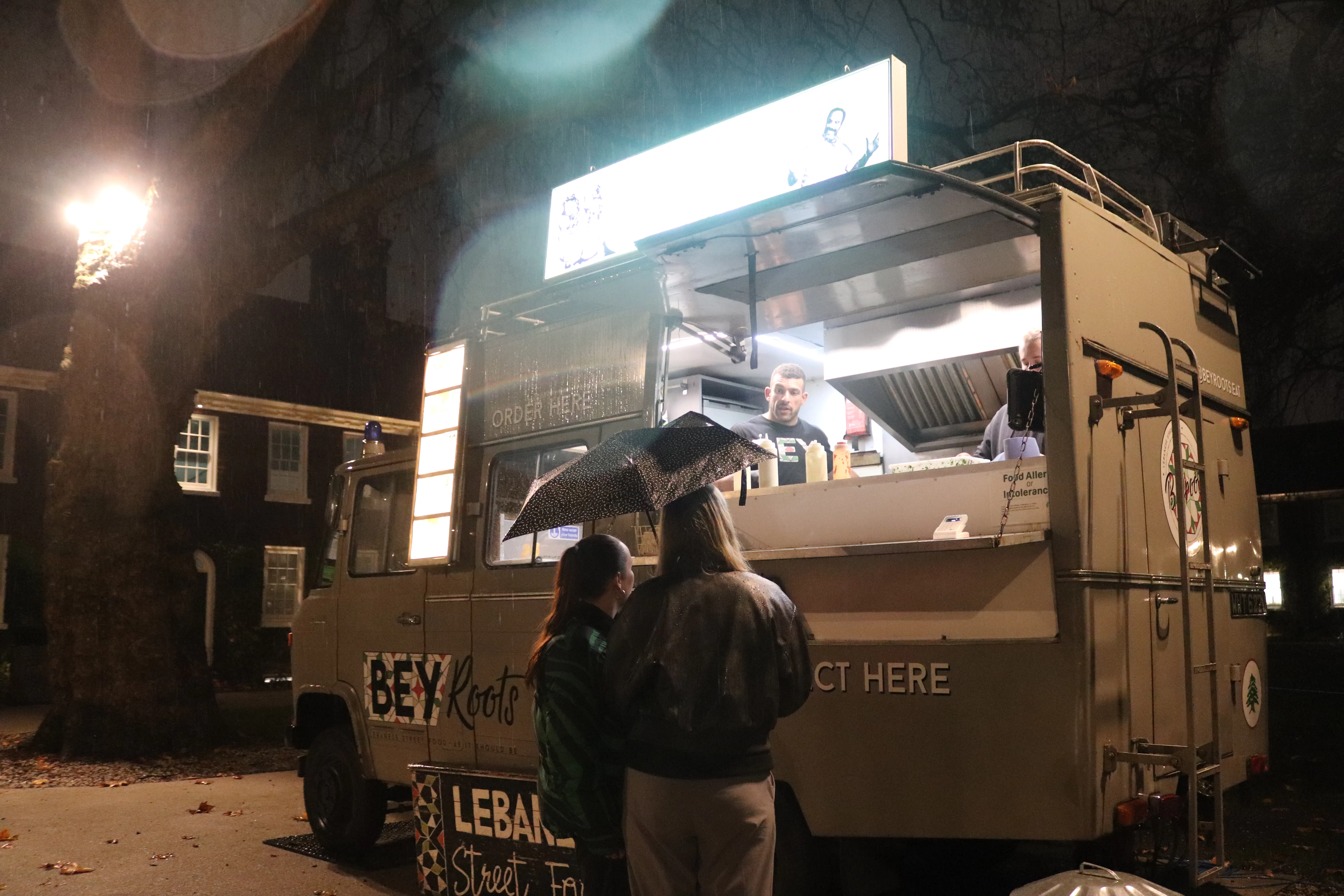 People queuing at a food truck at night during the sleep out event.