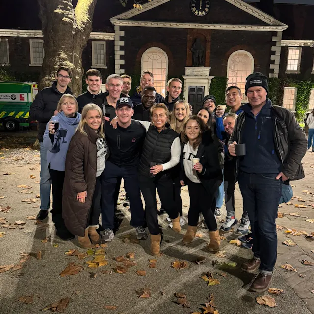 A group of participants standing outdoors at night, posing for a photo outside a historic building during the sleep out event.