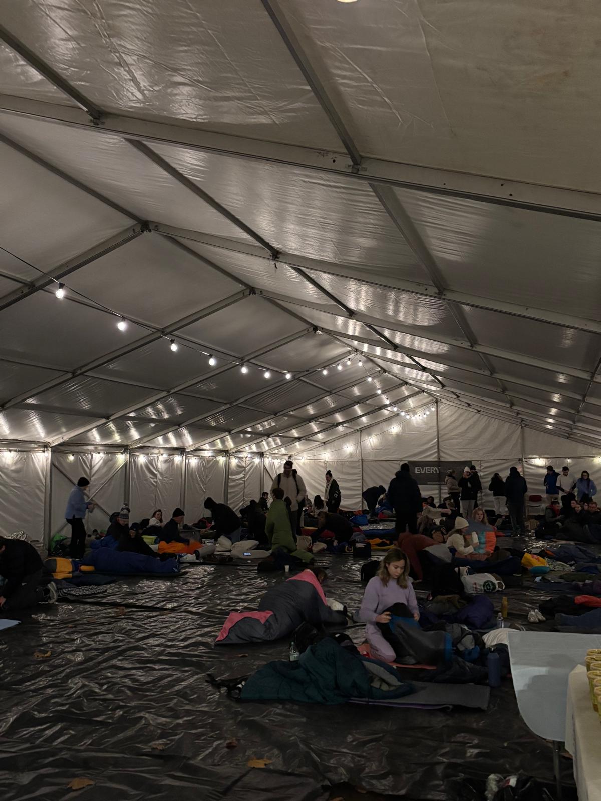 Participants inside a large marquee preparing sleeping bags for the sleep out.