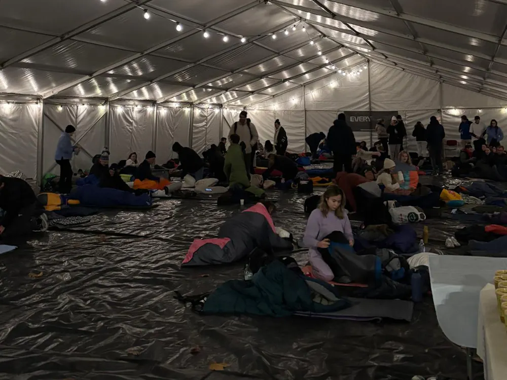 Participants inside a large marquee preparing sleeping bags for the sleep out.
