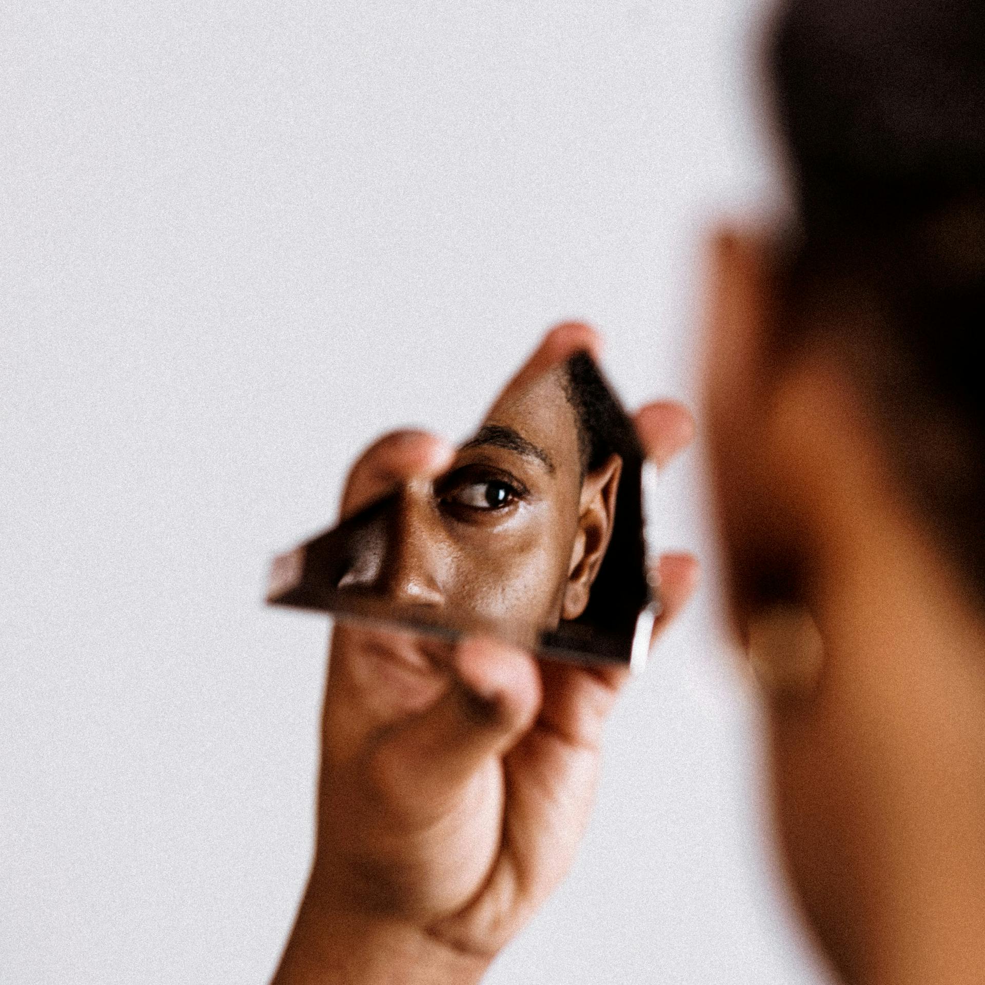 woman looking at broken mirror reflection