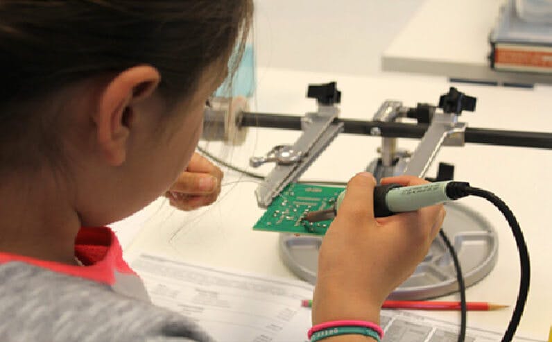 young girl with soldering iron