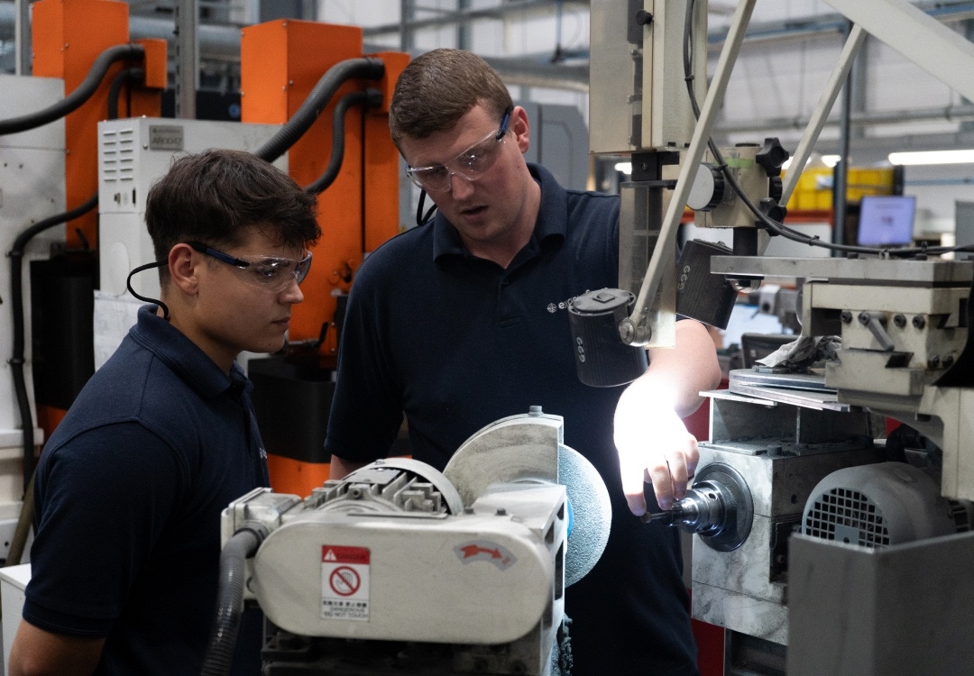 Two engineers inspecting a tool machine