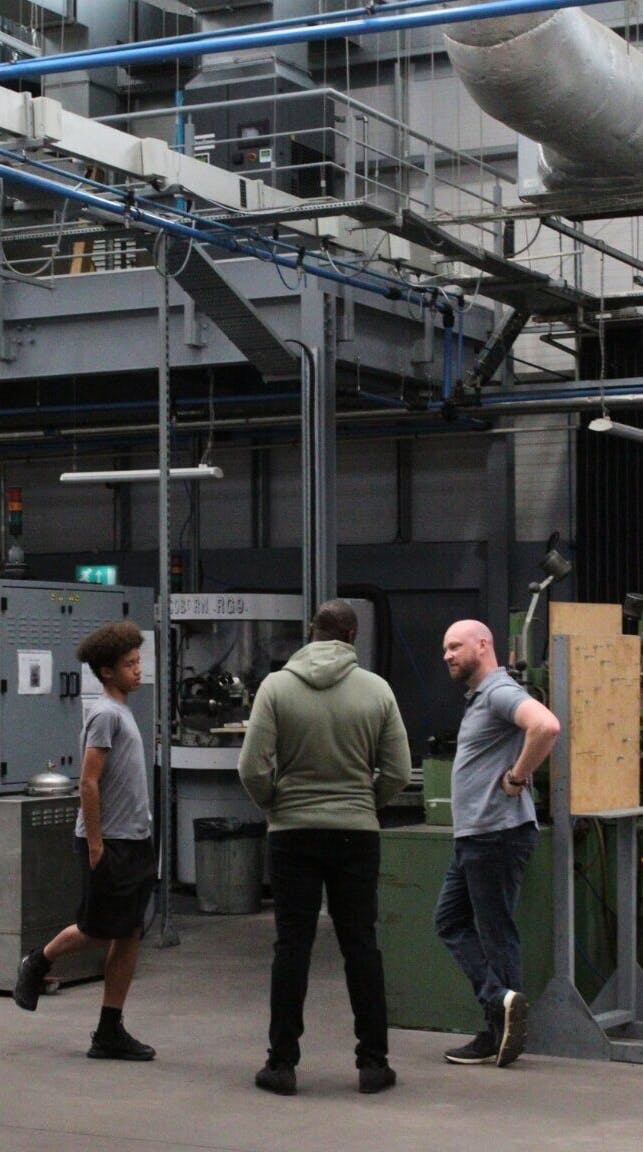 A photo of Jamie White and his employees talking in the Exactaform facility.